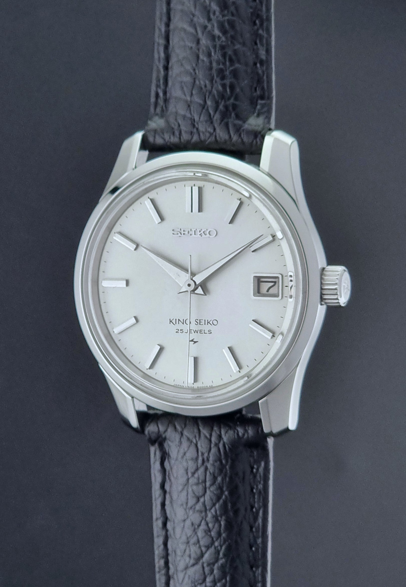 Vintage King Seiko Wristwatch with black leather strap on a dark background crown profile