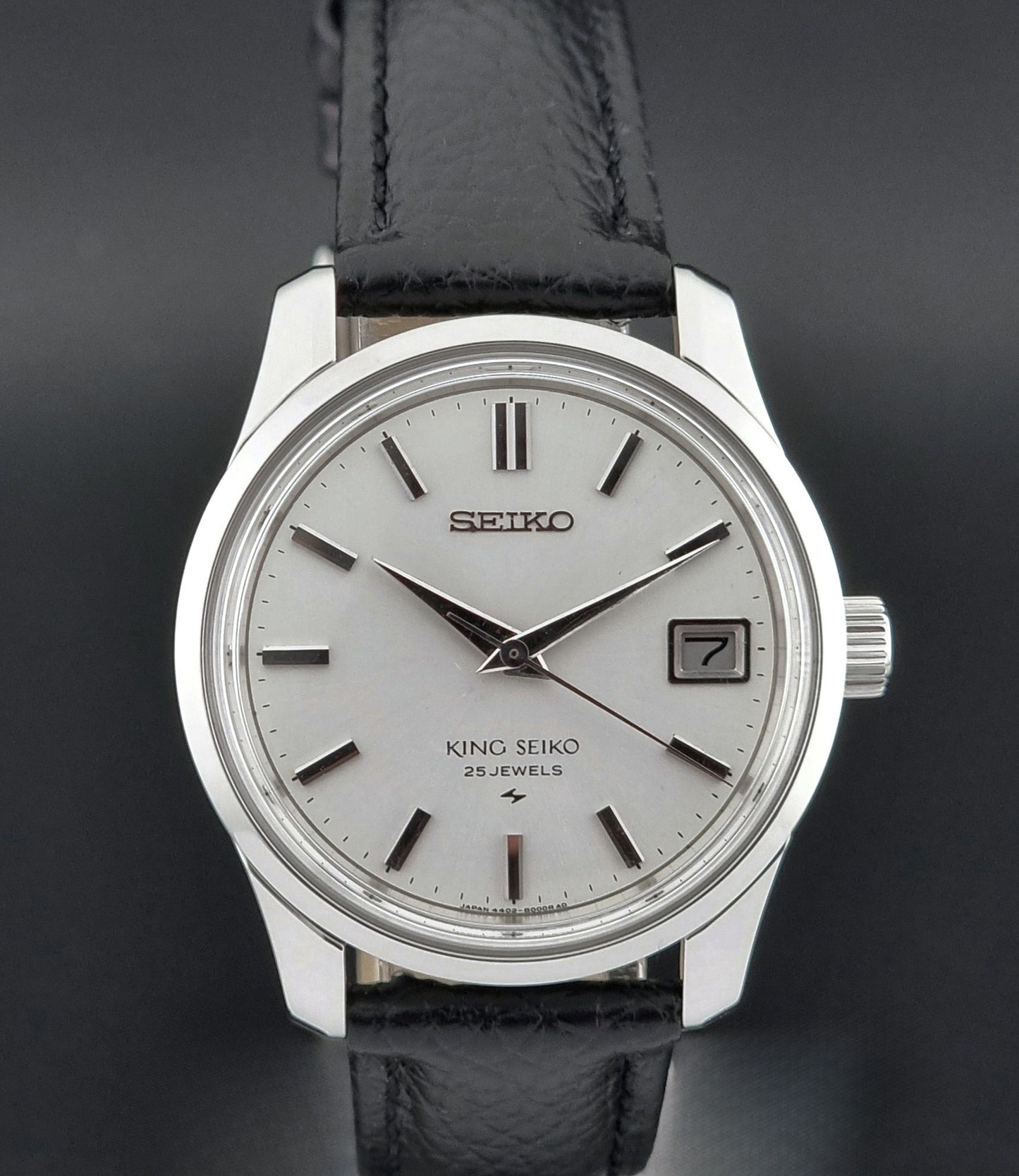 Vintage King Seiko Wristwatch with black leather strap on a dark background dial view