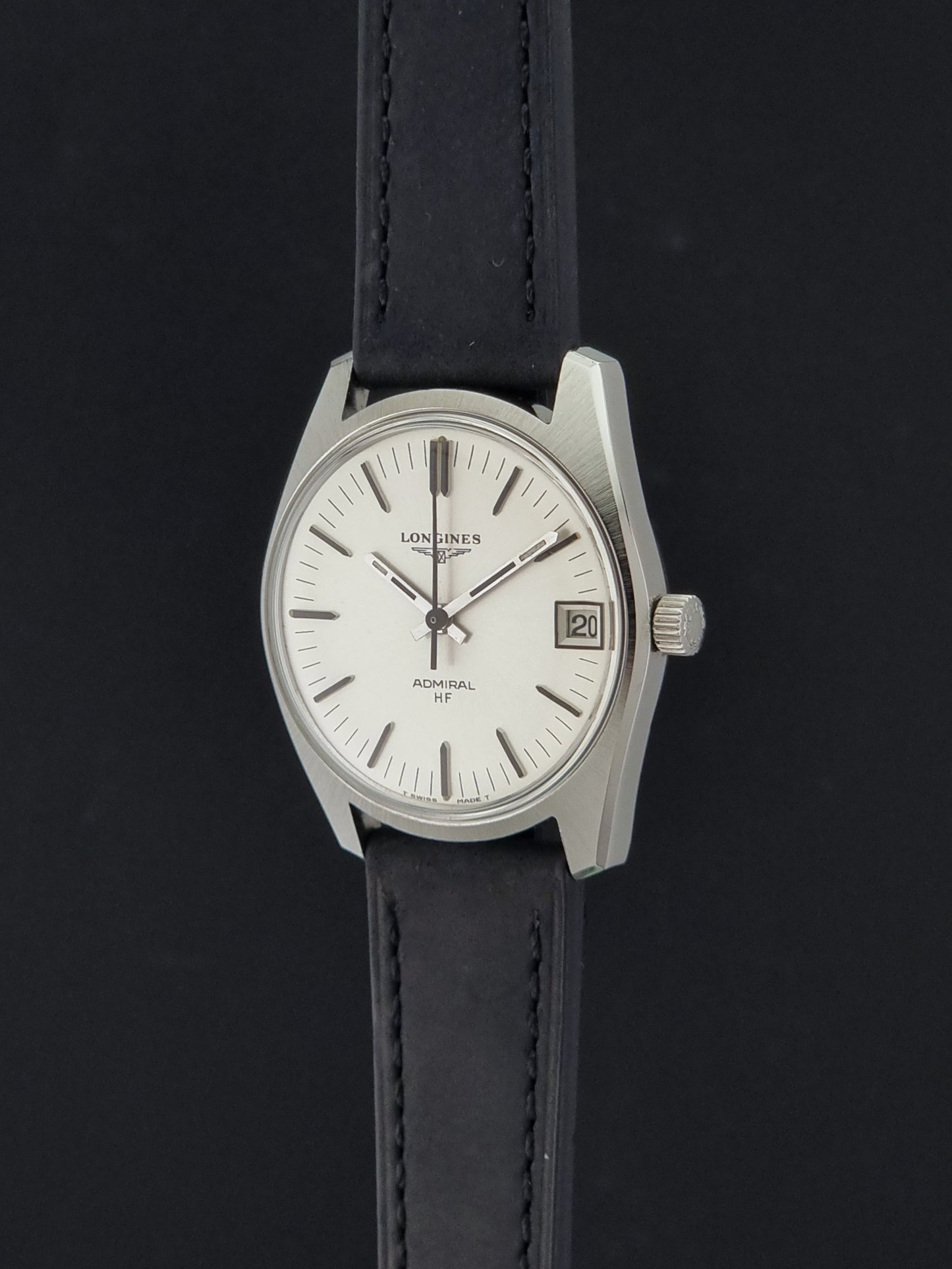 A Vintage Longines Admiral HF 2302 Wristwatch and black leather strap, photographed against a dark background.