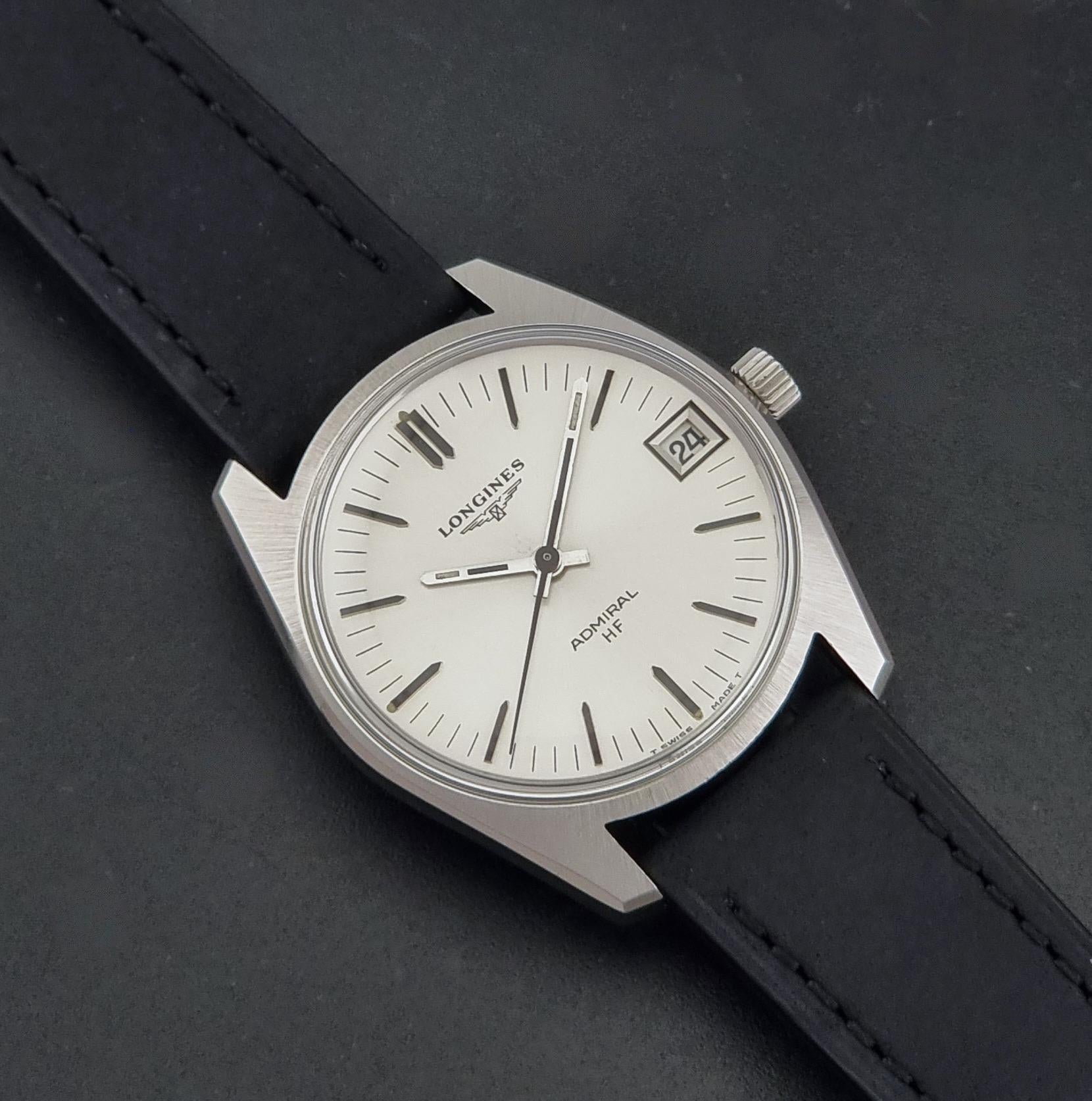 A Vintage Longines Admiral HF 2302 Wristwatch and black leather strap, photographed diagonally on a dark textured background.