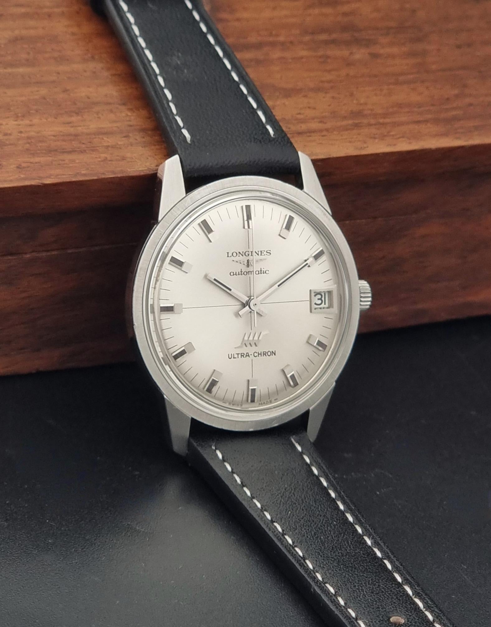 A Vintage Longines ULTRA-CHRON 8309 watch, resting on a wooden box