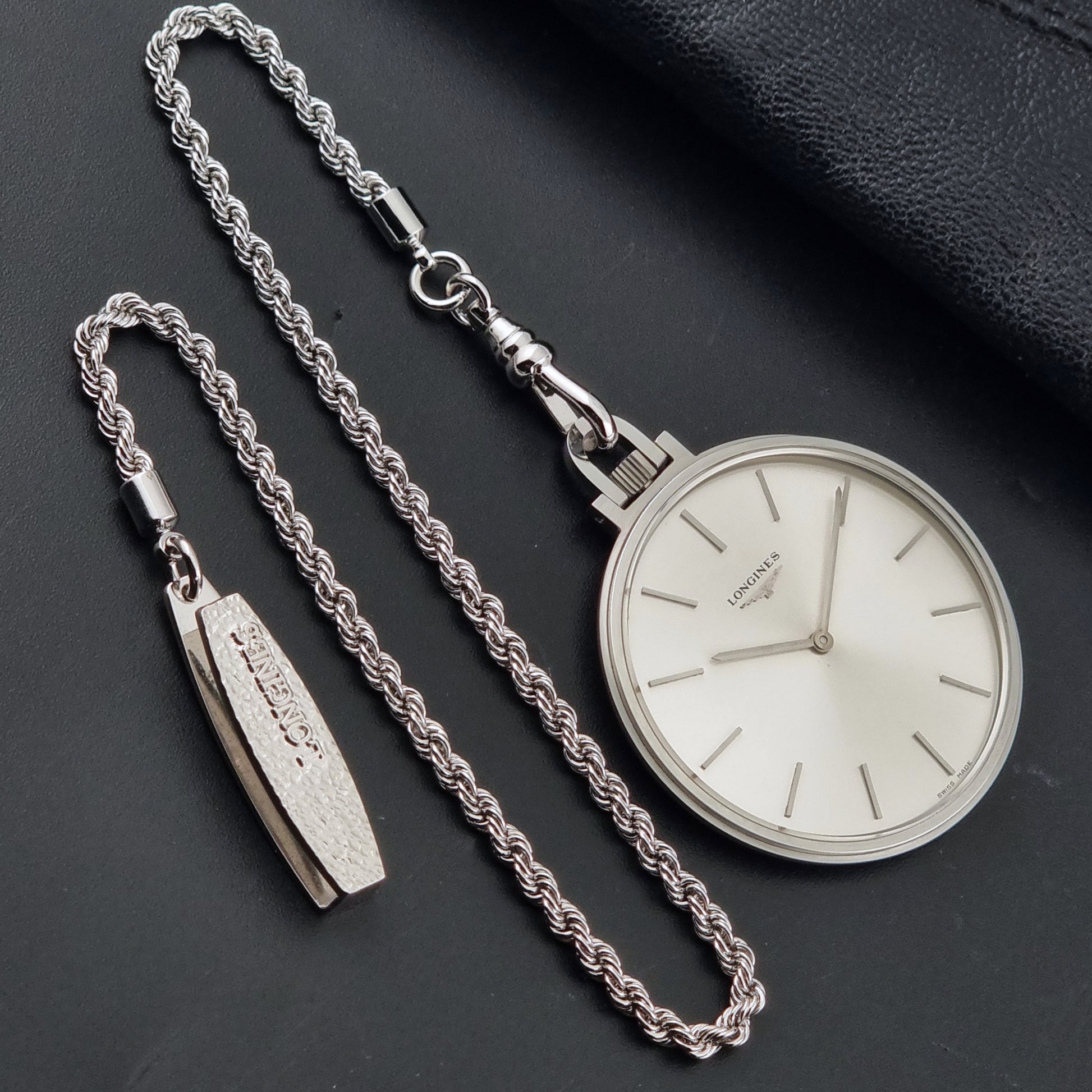 A Vintage Longines pocket watch on a dark background