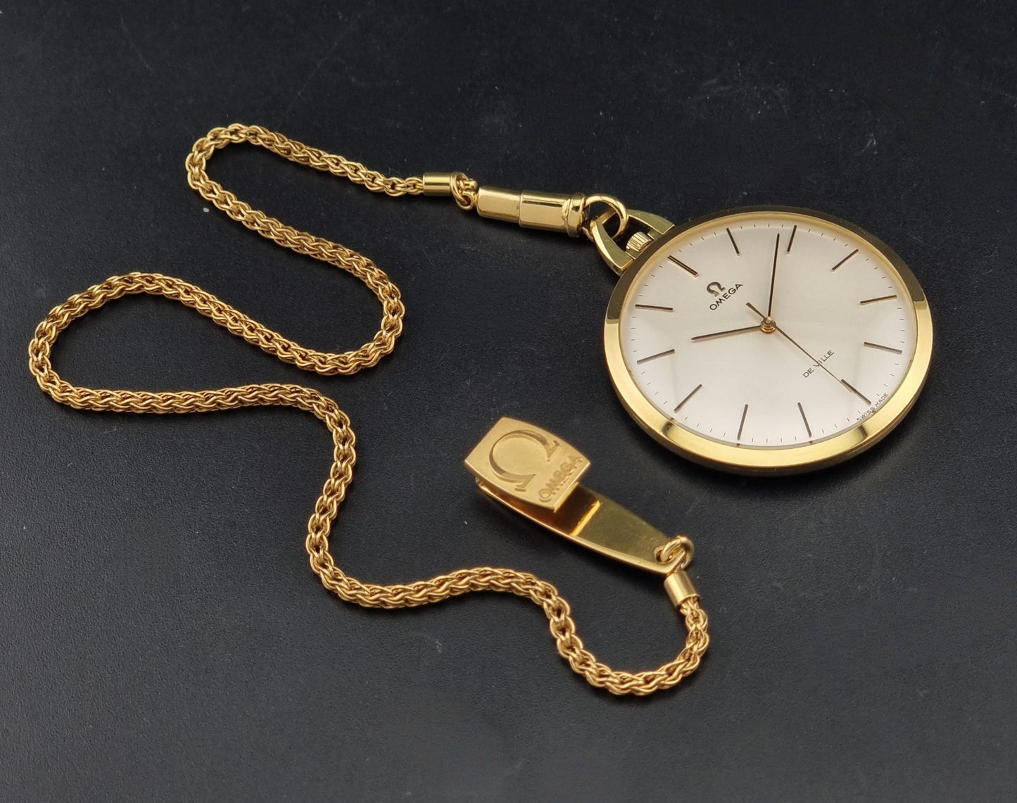 Vintage Omega De Ville Pocket Watch 1714 gold coloured on a dark background