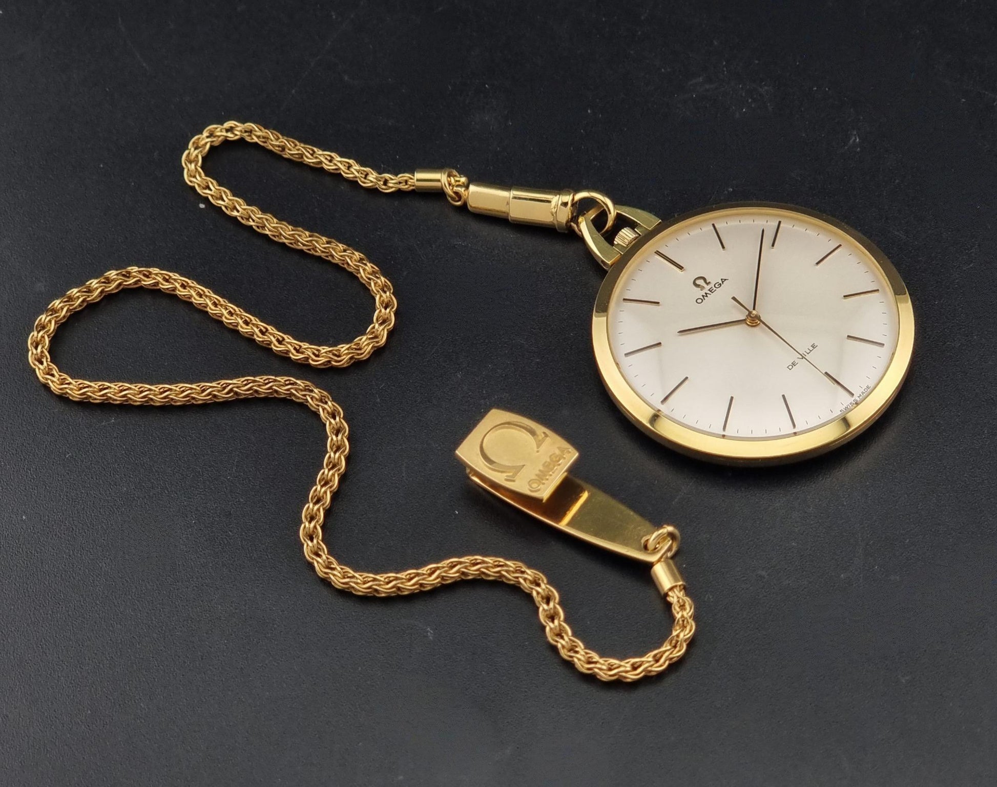 Vintage Omega De Ville Pocket Watch 1714 gold coloured on a dark background