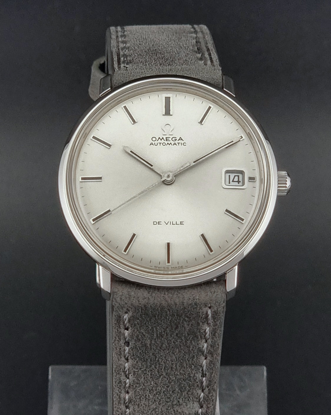 Vintage Omega watch with gray strap on a dark background