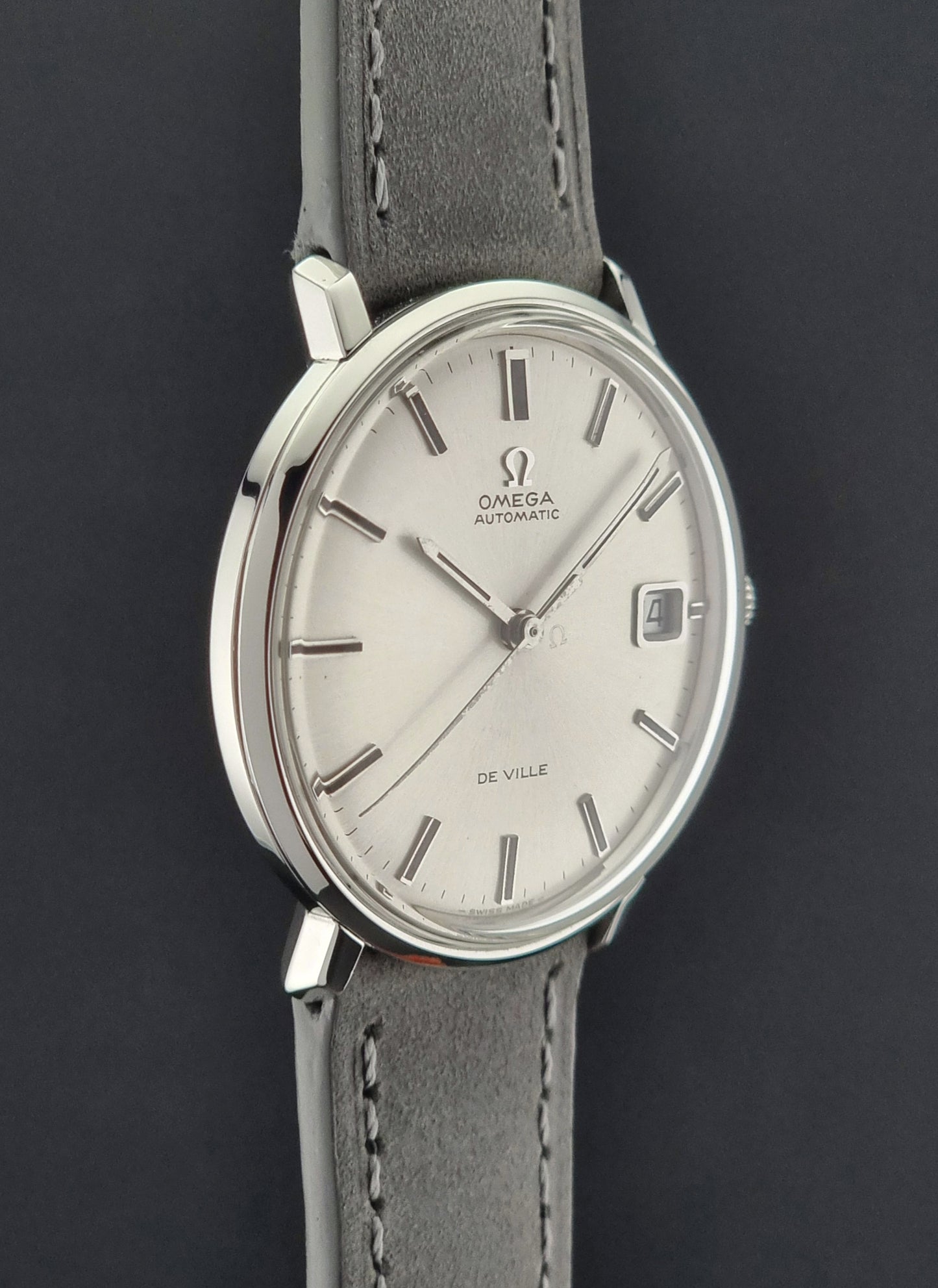 Vintage Omega watch with a gray strap on a dark background