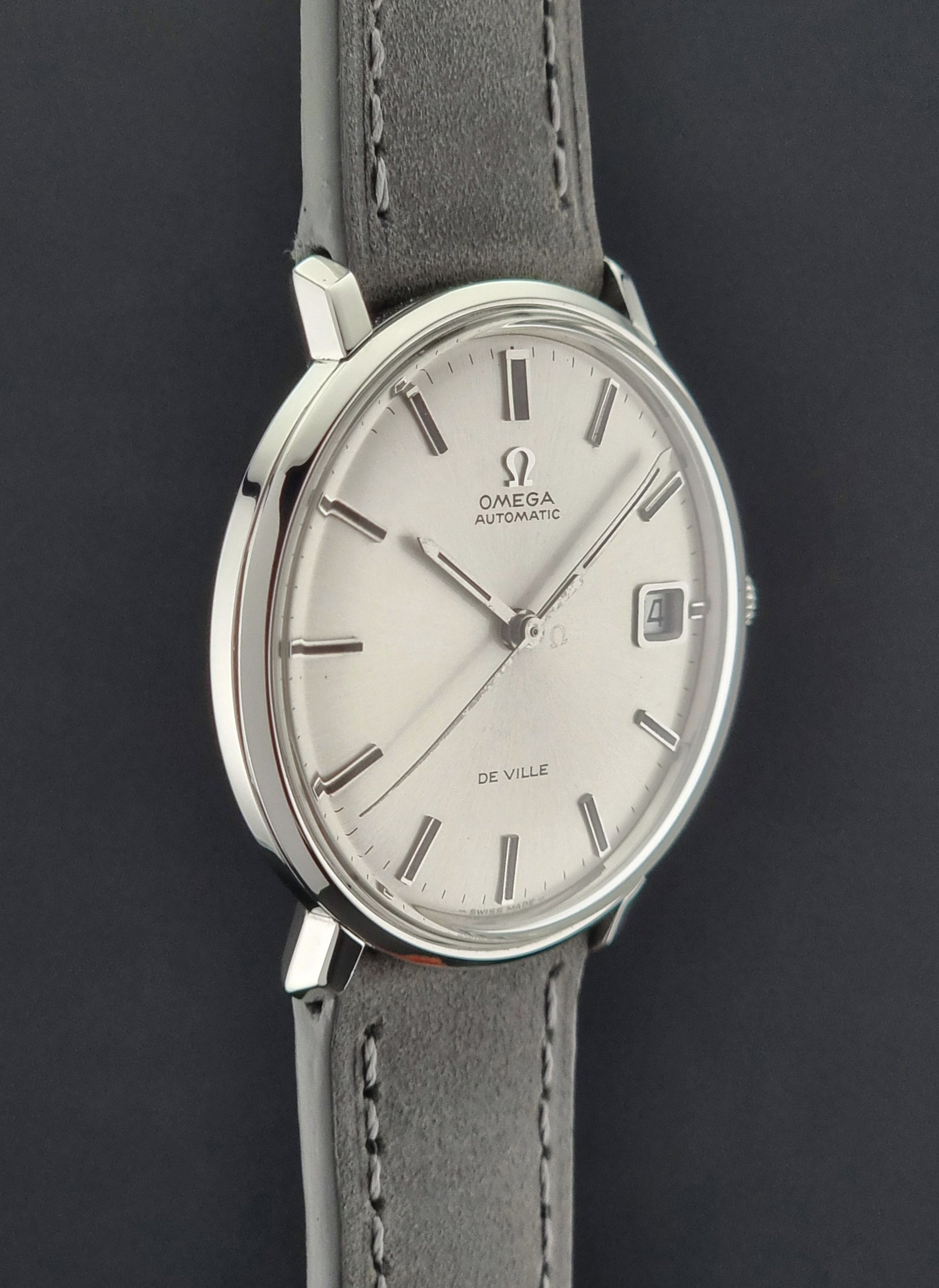 Vintage Omega watch with a gray strap on a dark background