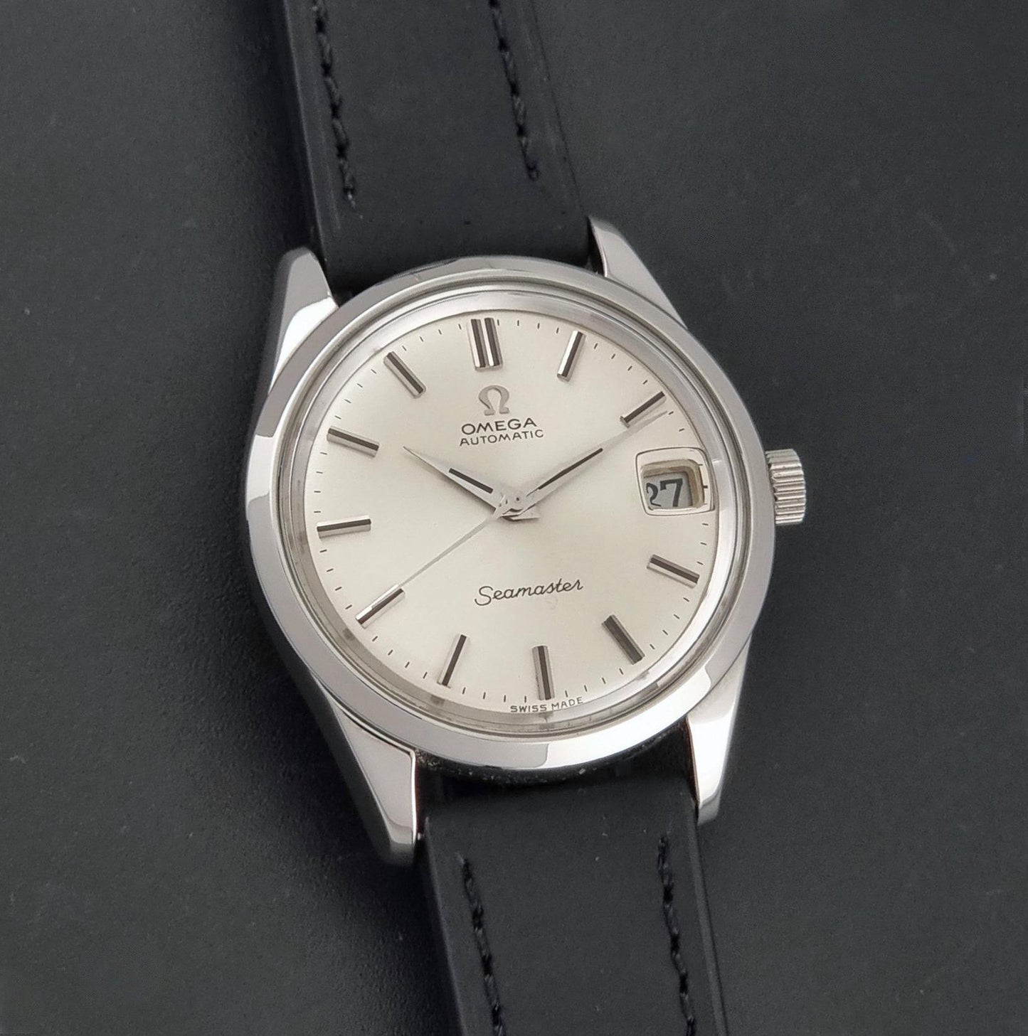 A Vintage Omega Seamaster 166.010 Wristwatch close up of the dial on a dark background