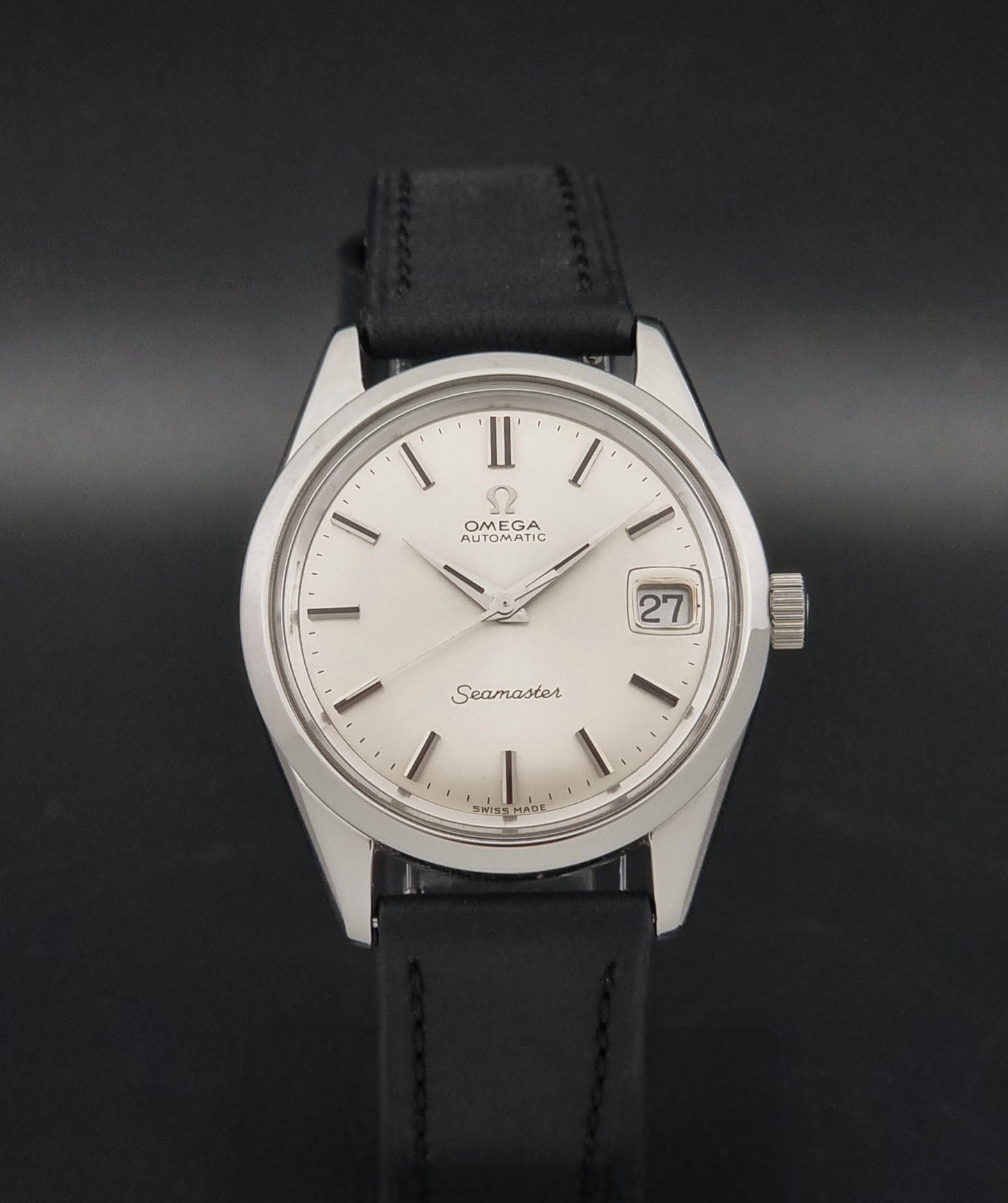 A Vintage Omega Seamaster 166.010 Wristwatch on a dark background 