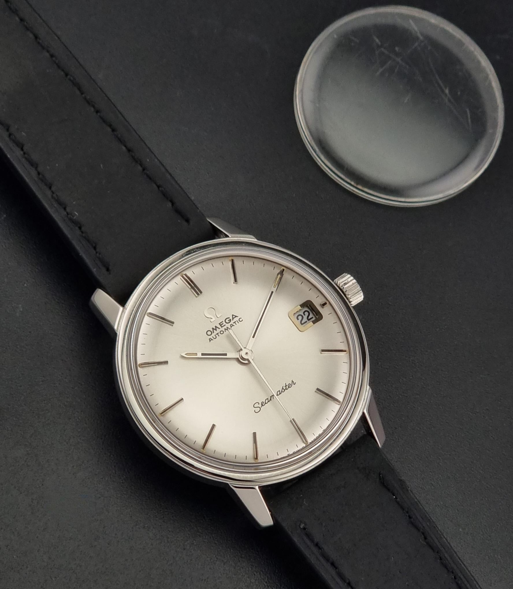 A Vintage Omega Seamaster watch 166.037 wristwatch  with a spare original crystal on a dark background