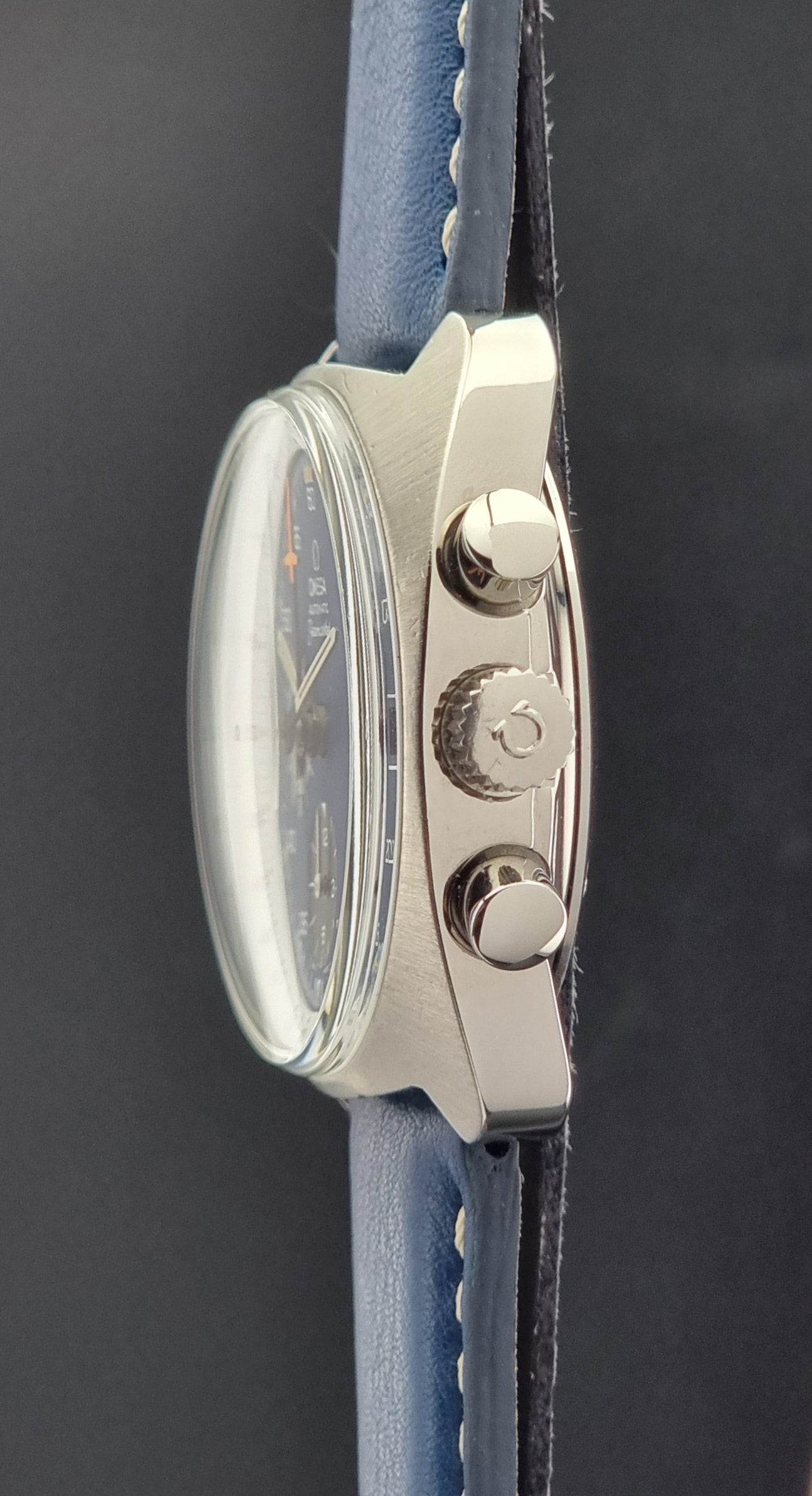 Vintage Omega Seamaster Watch with blue strap and silver case on a dark background