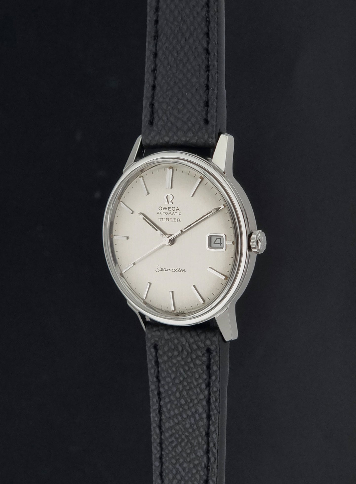 A Vintage Omega Seamaster Wristwatch 166.002 Turler dial on a dark background crown side view