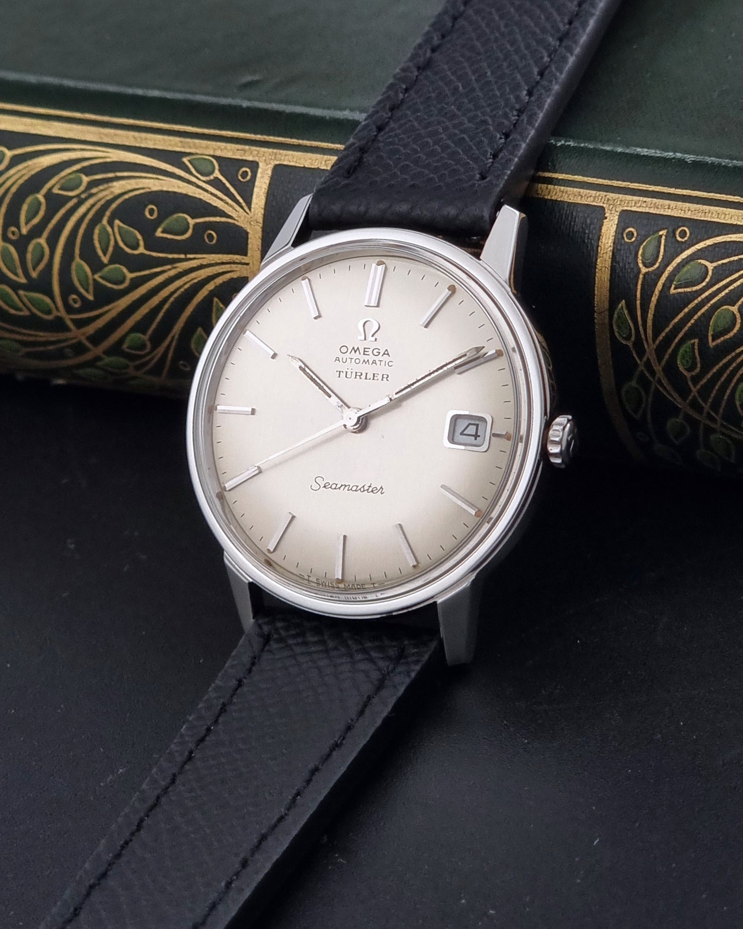 A Vintage Omega Seamaster Wristwatch 166.002 Turler dial on a dark background side with crown view