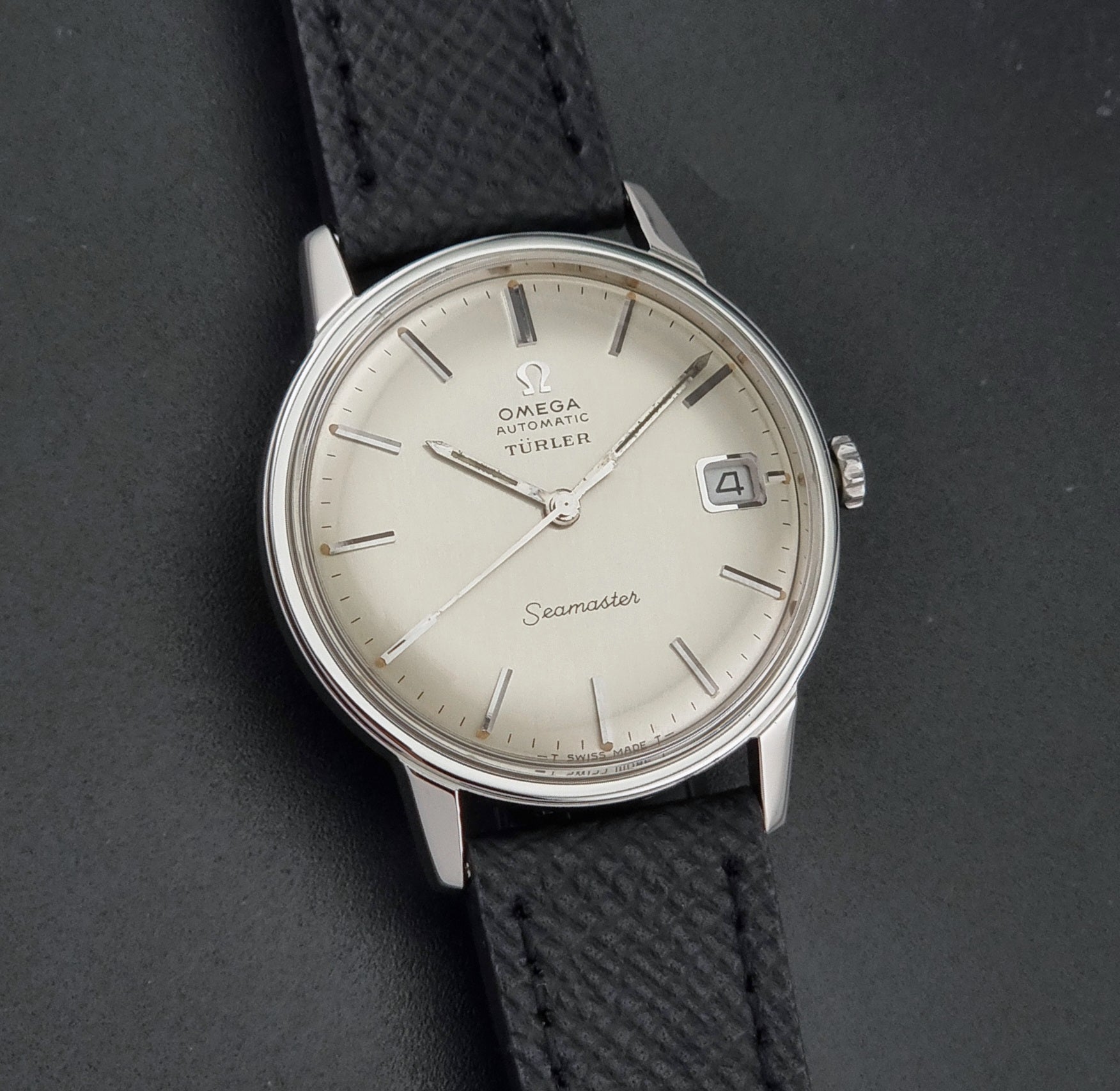 A Vintage Omega Seamaster Wristwatch 166.002 Turler dial on a dark background dial close up