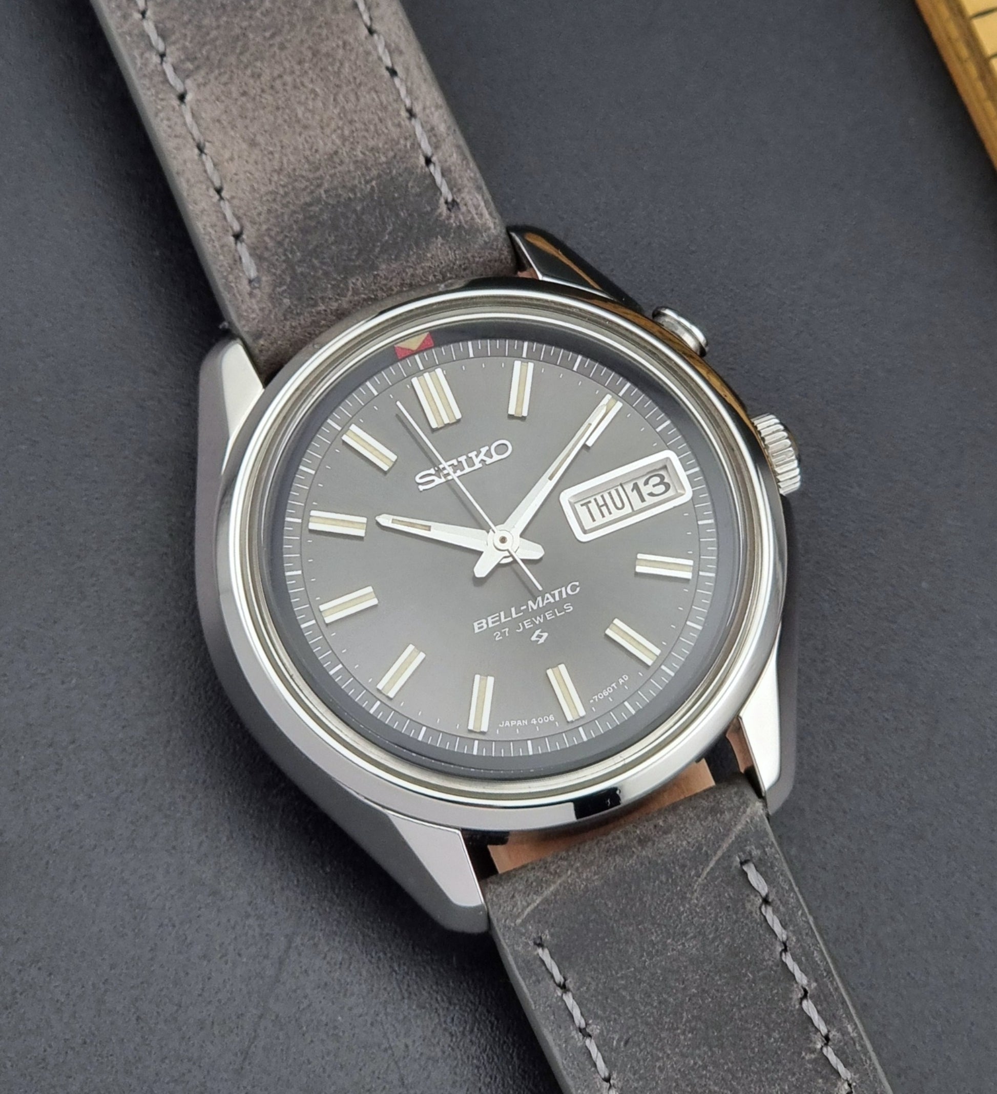 Seiko Bell-Matic watch with gray leather strap on a dark surface