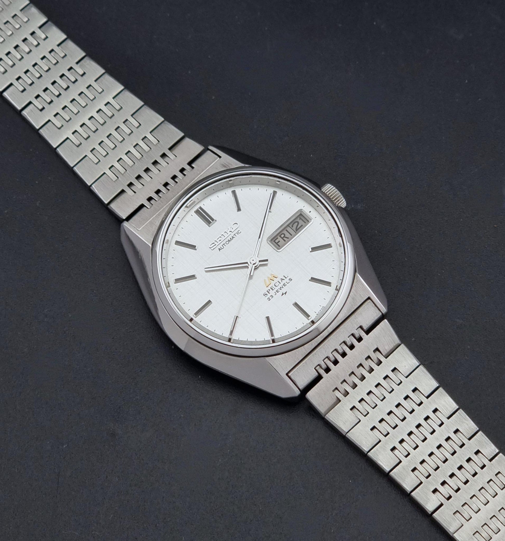 A Vintage Seiko LordMatic Special 5216-8020 Wristwatch, photographed diagonally on a dark textured background.