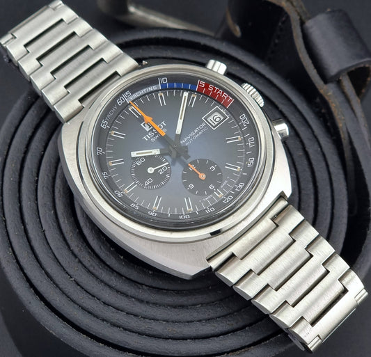 Vintage Tissot wristwatch with detailed face on a textured black background