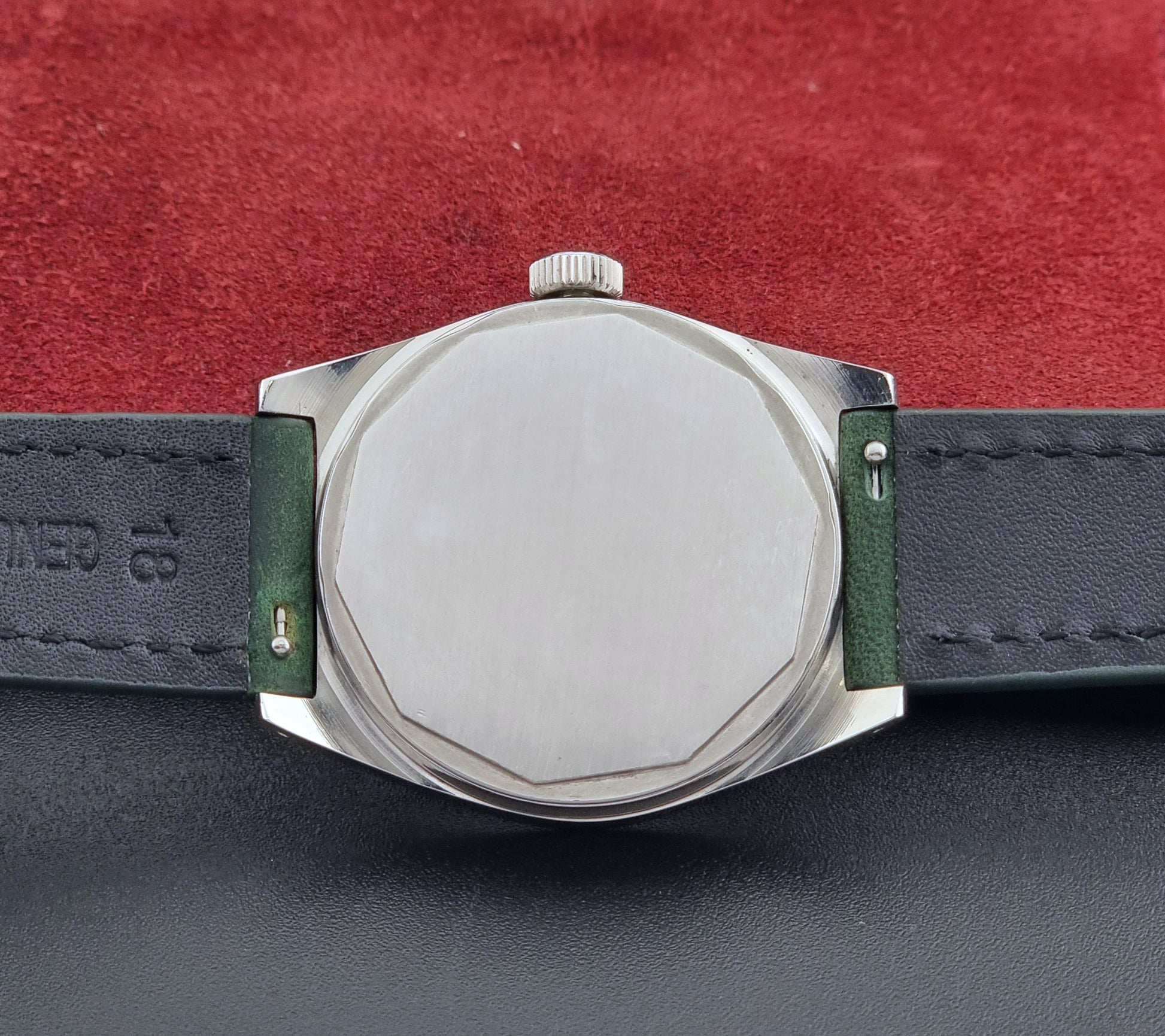 Vintage Tissot 41620 PR 516 wristwatch with green strap and silver case on a gray background case back view