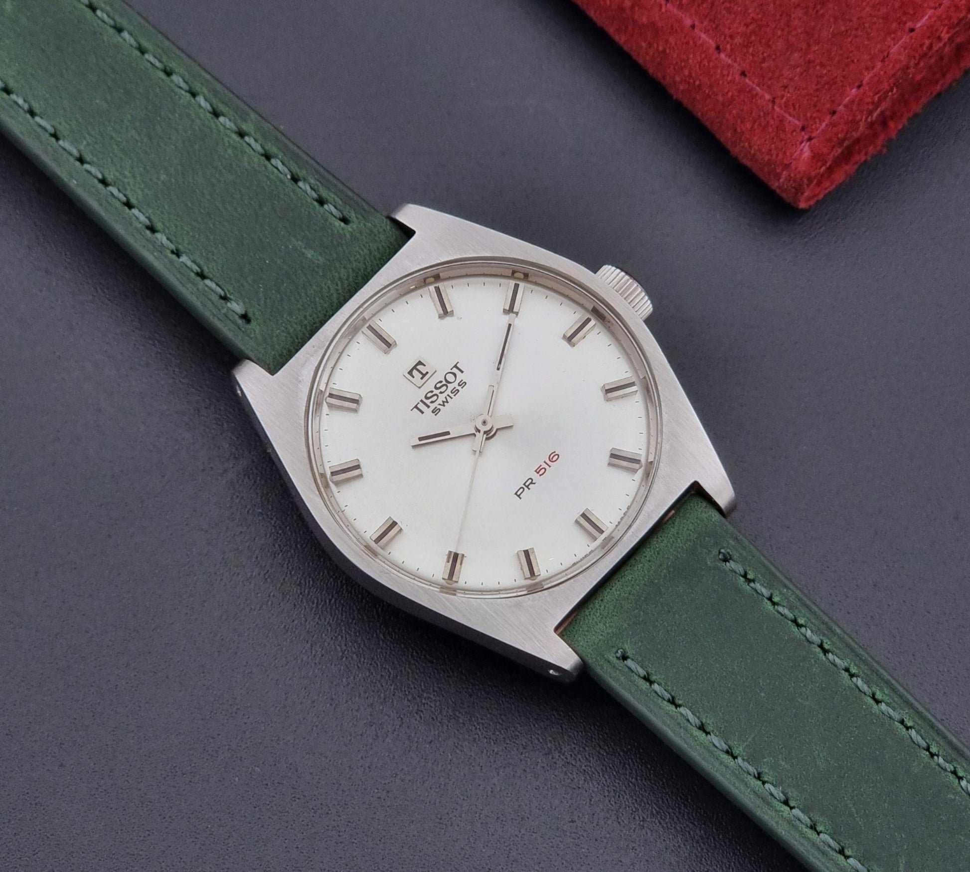 Vintage Tissot 41620 PR 516 wristwatch with green strap and silver case on a gray background front