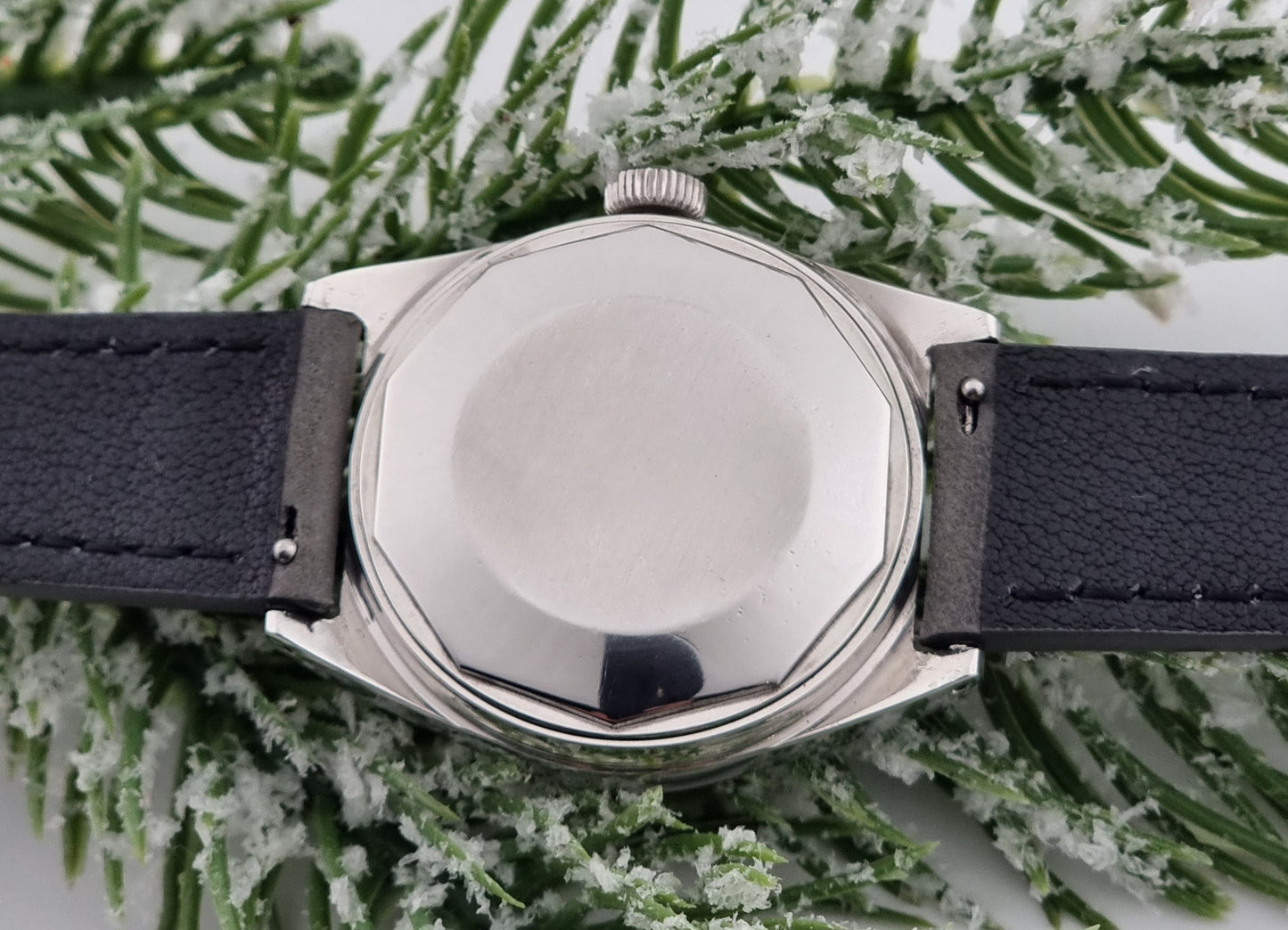 Vintage Tissot Seastar Visodate 43516 wristwatch with grey leather strap on a snowy branch background case back view