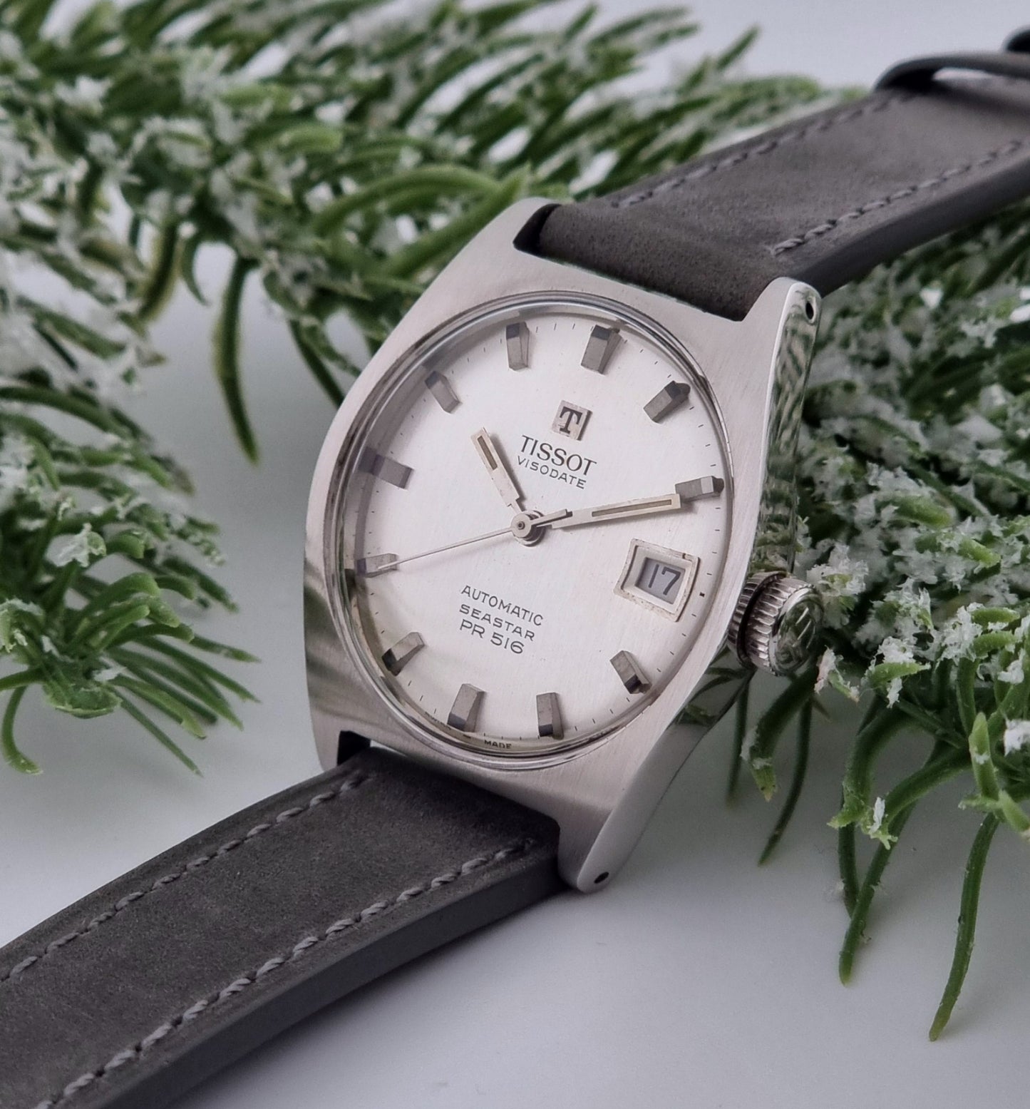 Vintage Tissot Seastar Visodate 43516 wristwatch with grey leather strap on a snowy branch background crown view
