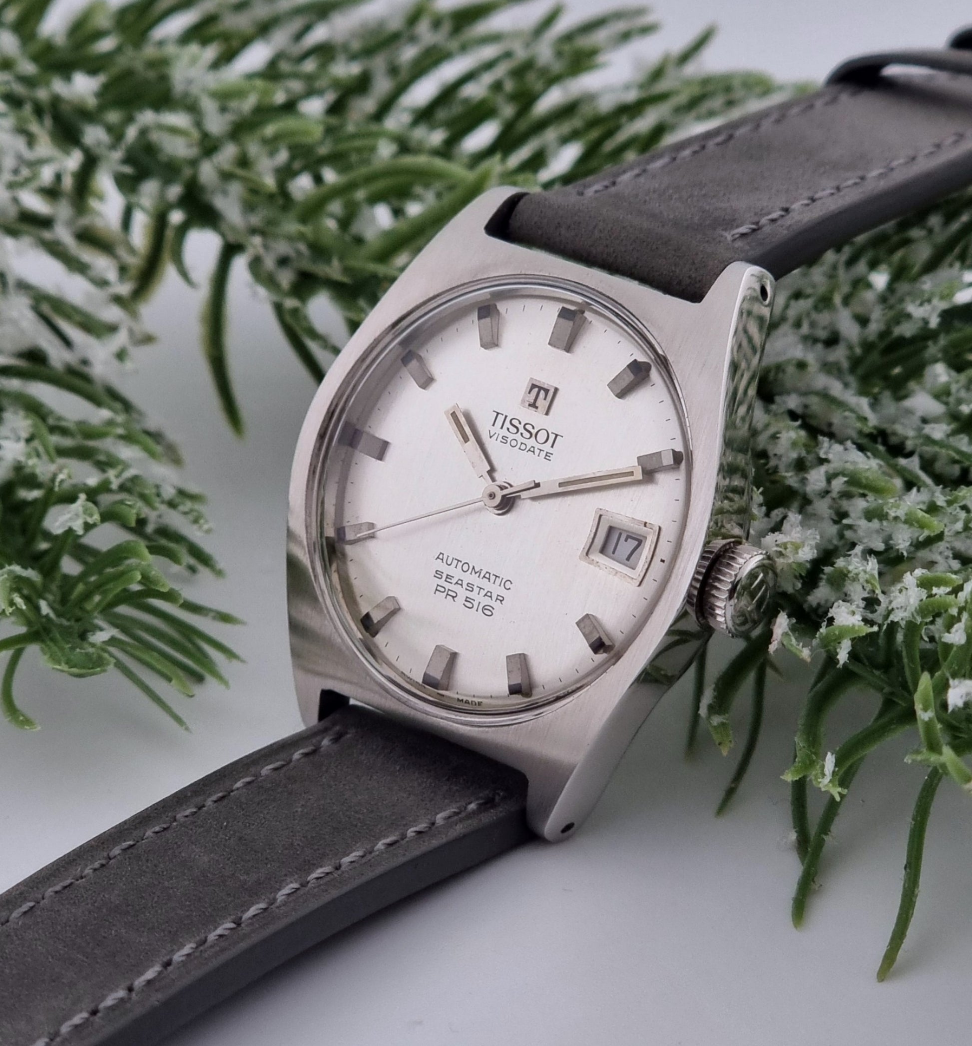 Vintage Tissot Seastar Visodate 43516 wristwatch with grey leather strap on a snowy branch background crown view