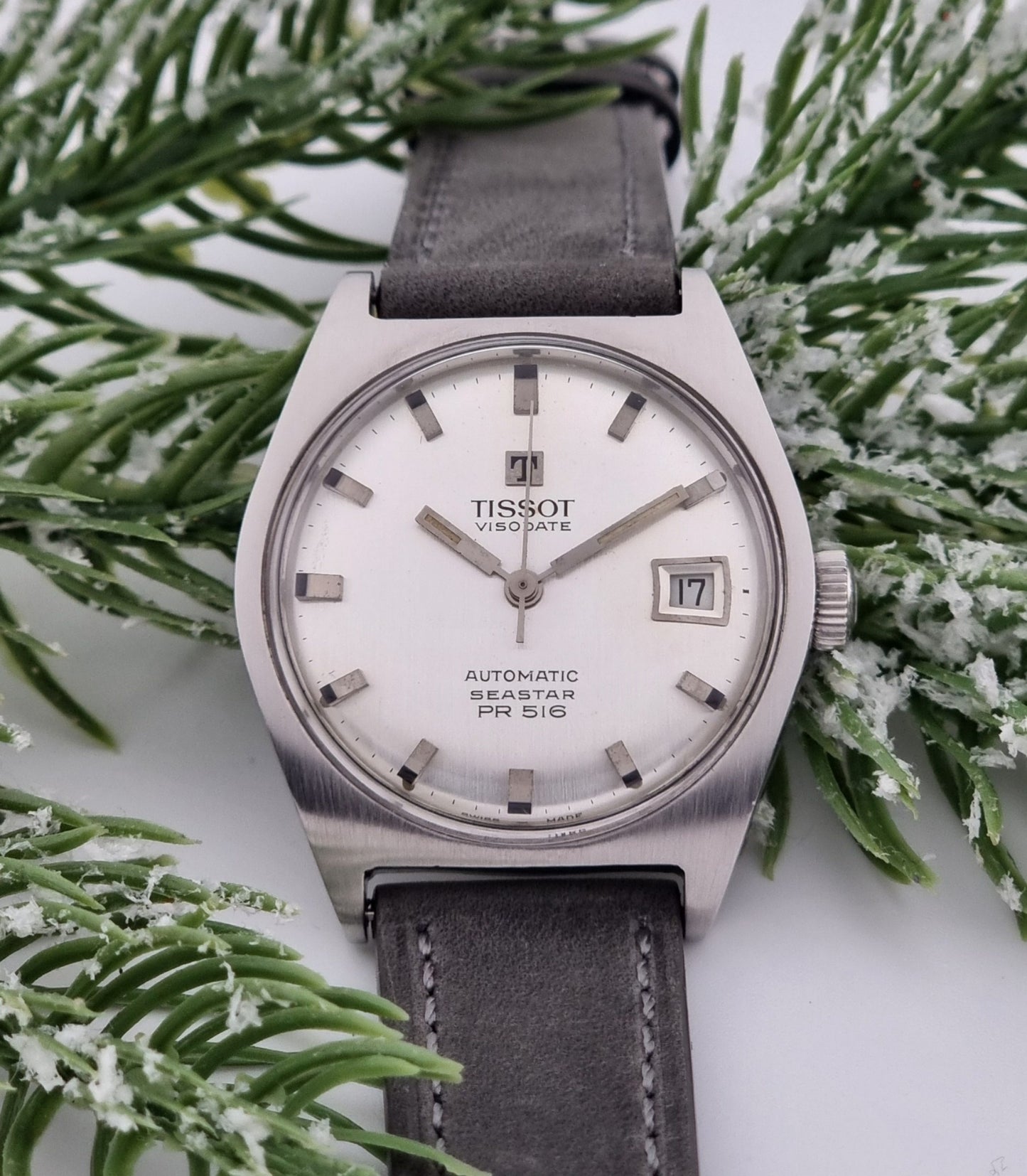 Vintage Tissot Seastar Visodate 43516 wristwatch with grey leather strap on a snowy branch background close dial view