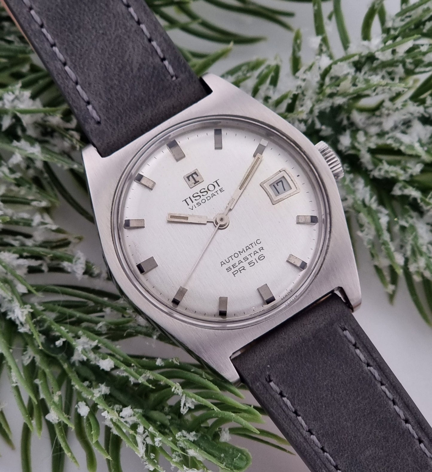 Vintage Tissot Seastar Visodate 43516 wristwatch with grey leather strap on a snowy branch background dial view