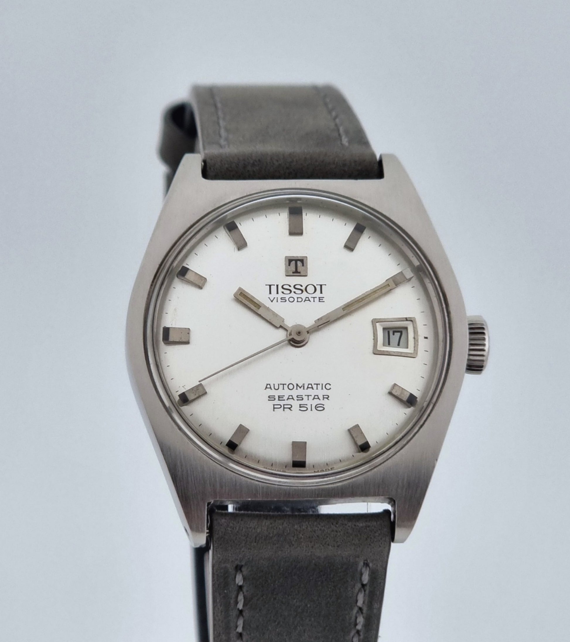 Vintage Tissot Seastar Visodate 43516 wristwatch with grey leather strap on a snowy branch background close front view