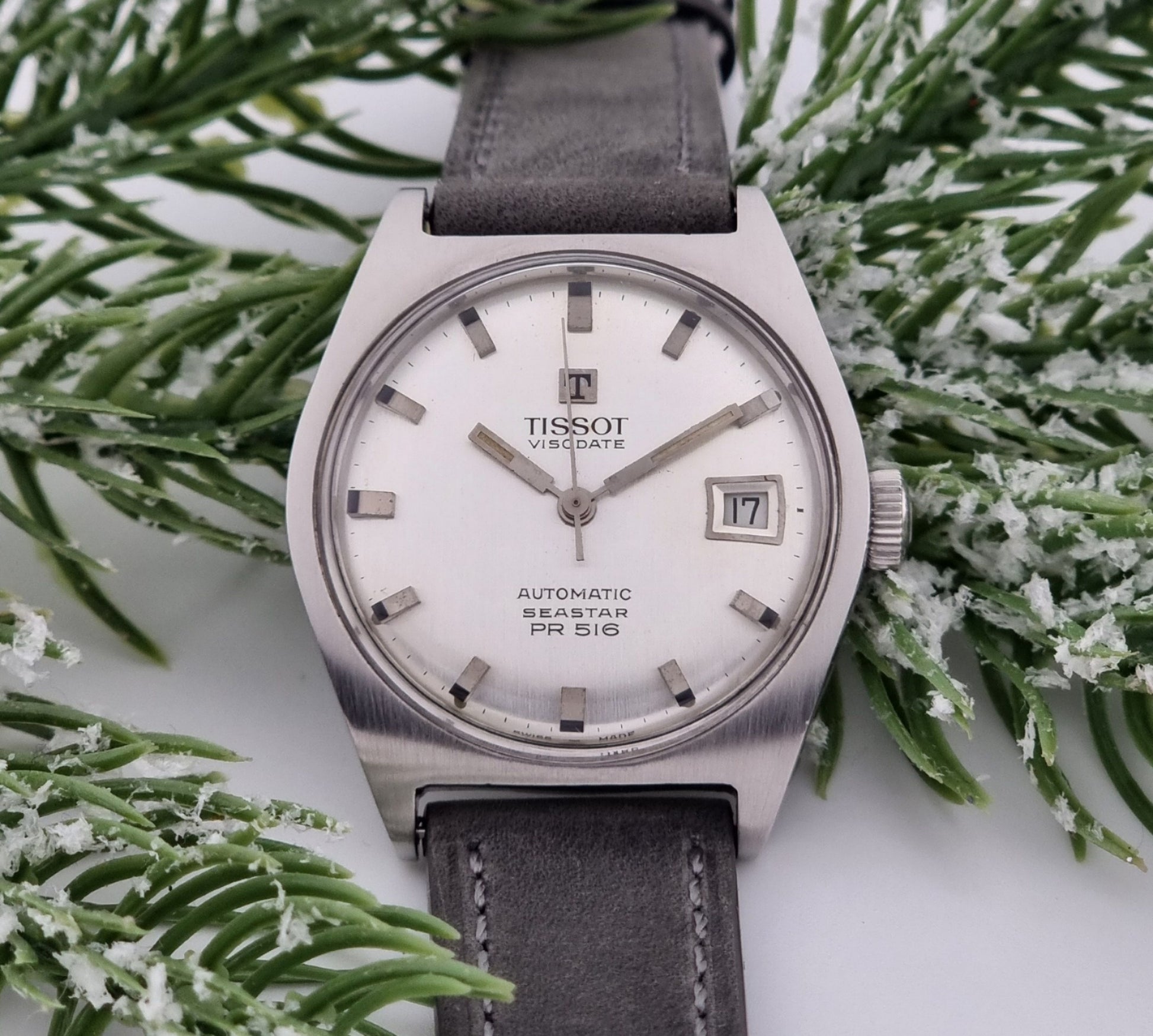 Vintage Tissot Seastar Visodate 43516 wristwatch with grey leather strap on a snowy branch background front 