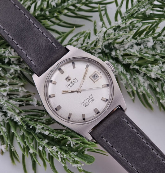 Vintage Tissot Seastar Visodate 43516 wristwatch with grey leather strap on a snowy branch background front view