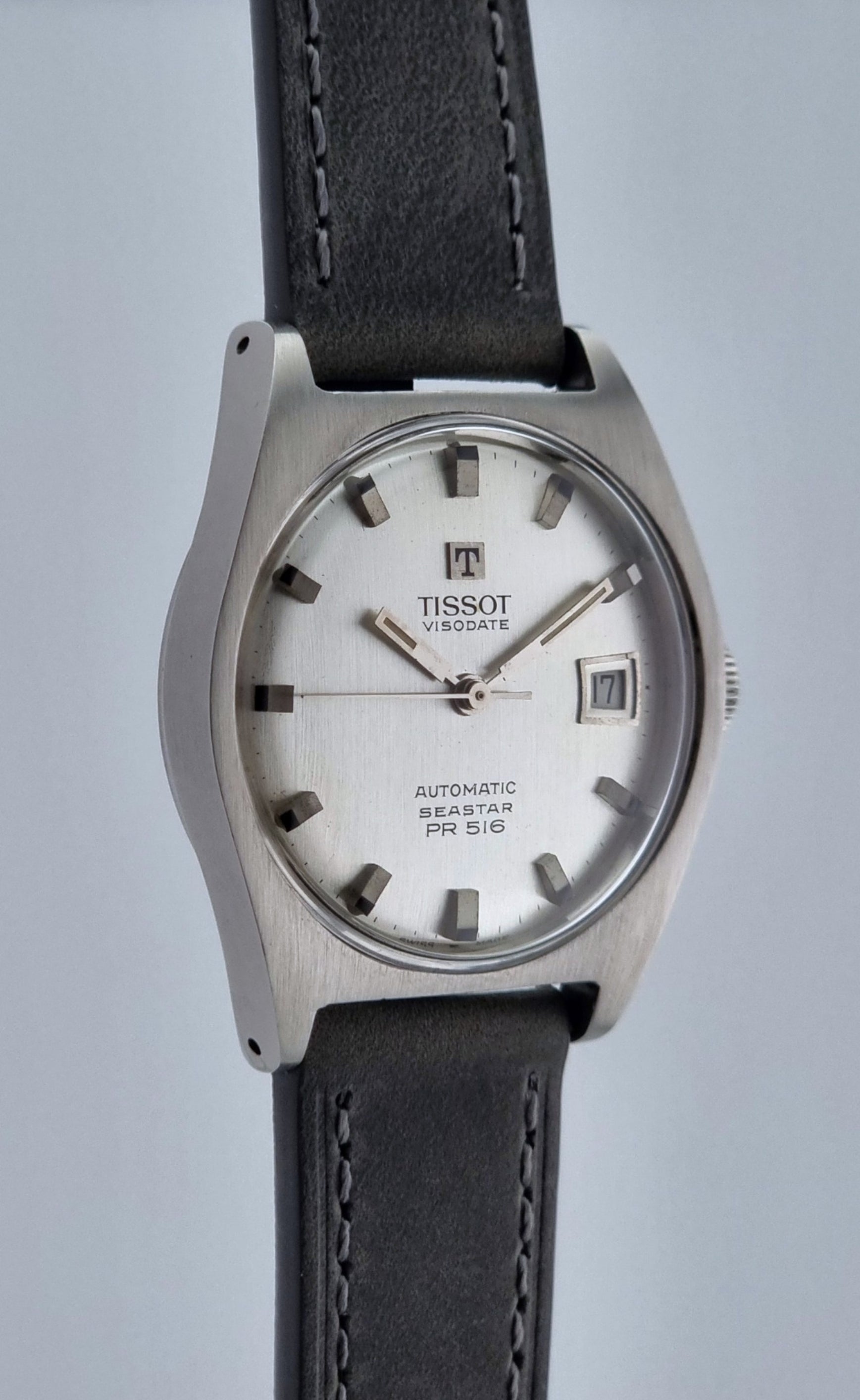 Vintage Tissot Seastar Visodate 43516 wristwatch with grey leather strap on a light background side profile view