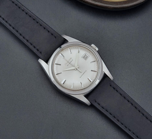 Vintage Bulova wristwatch 394-2 with black leather strap on a dark gray background dial