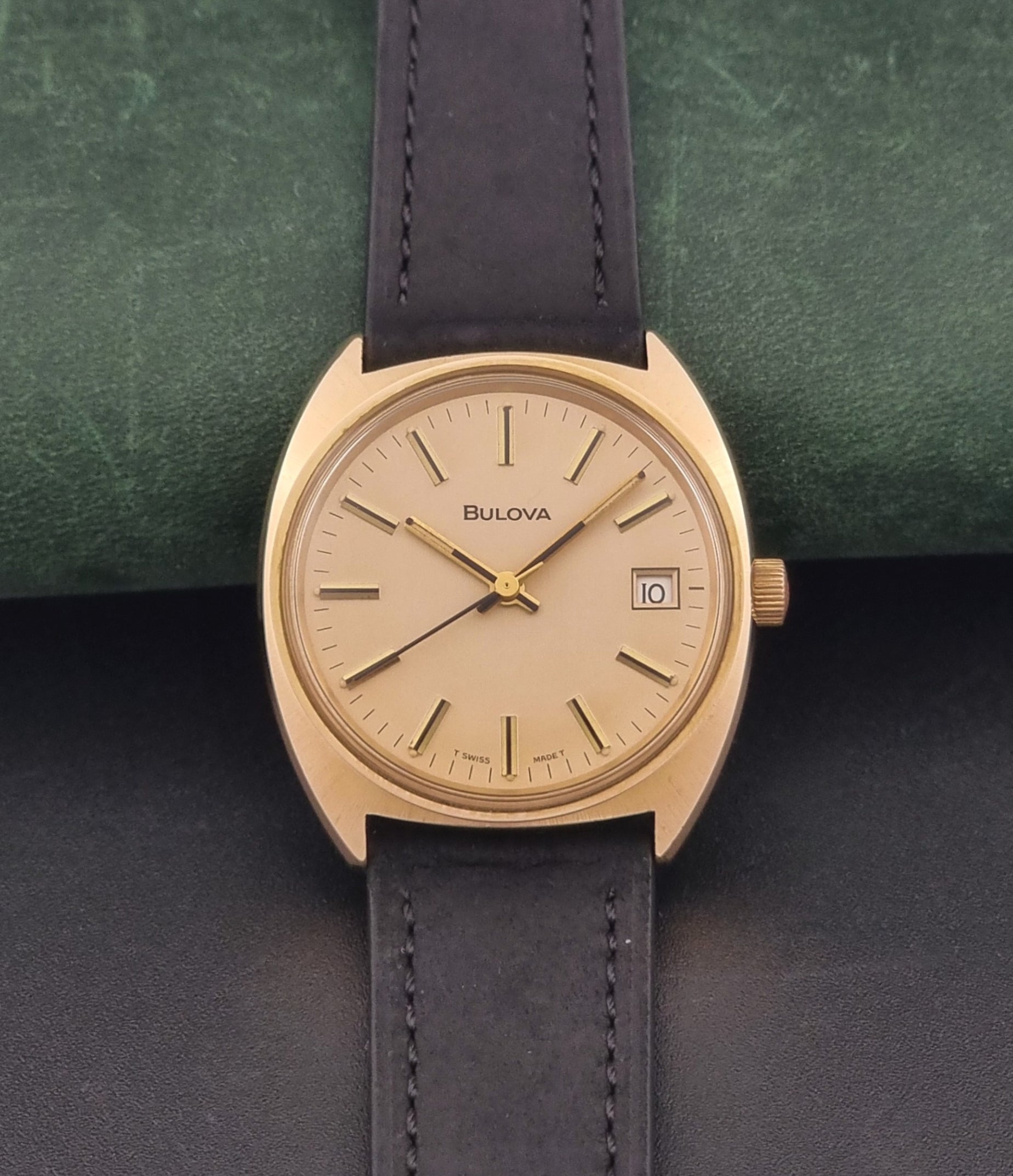 Vintage Bulova wristwatch 7530-1 with black leather strap on a gray surface dial view