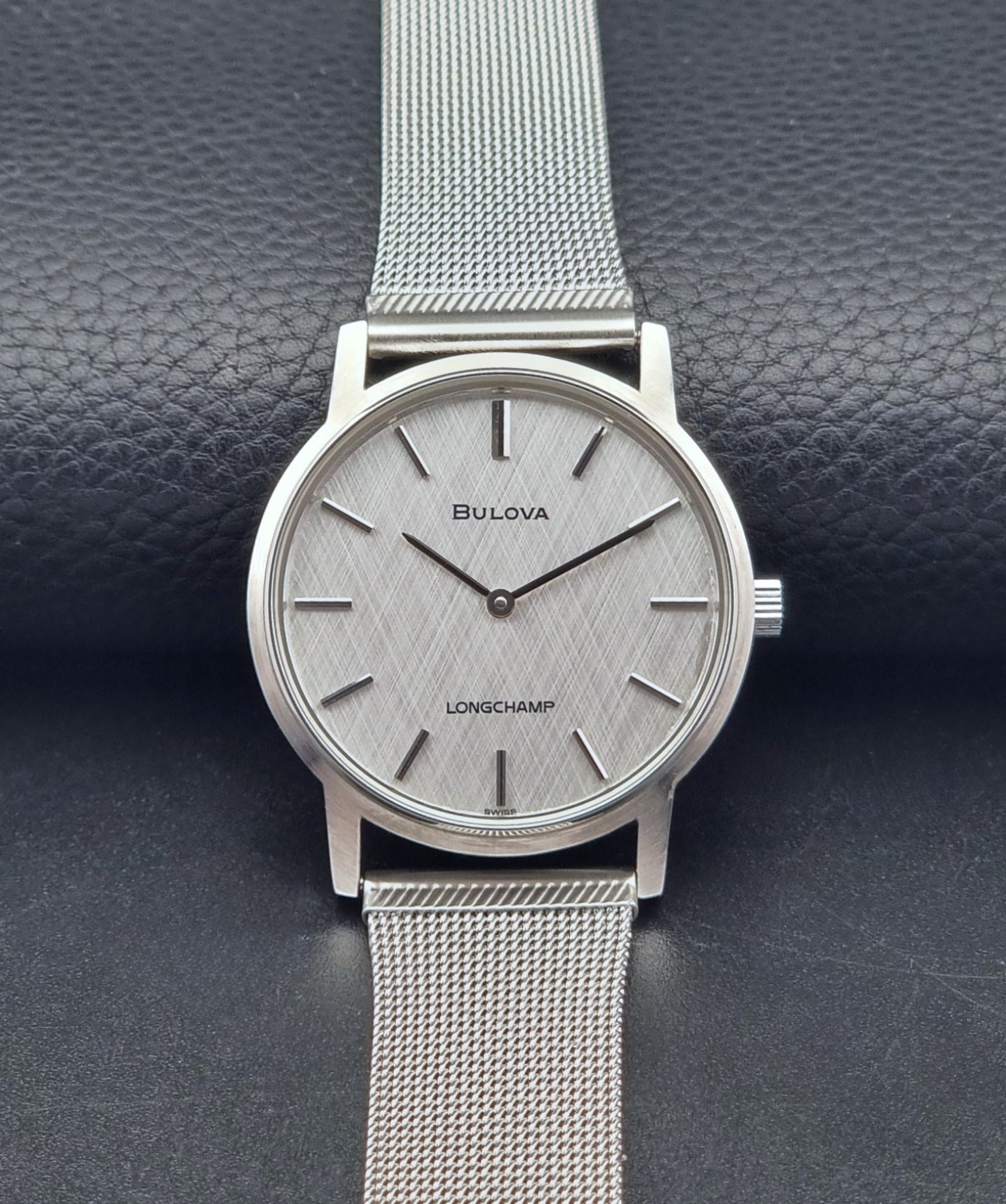 Vintage Bulova 9881 wristwatch Longchamps co-signed dial with a mesh band on a dark gray background dial view