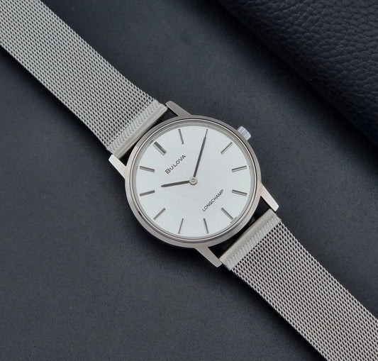 Vintage Bulova 9881 wristwatch Longchamps co-signed dial with a mesh band on a dark gray background dial