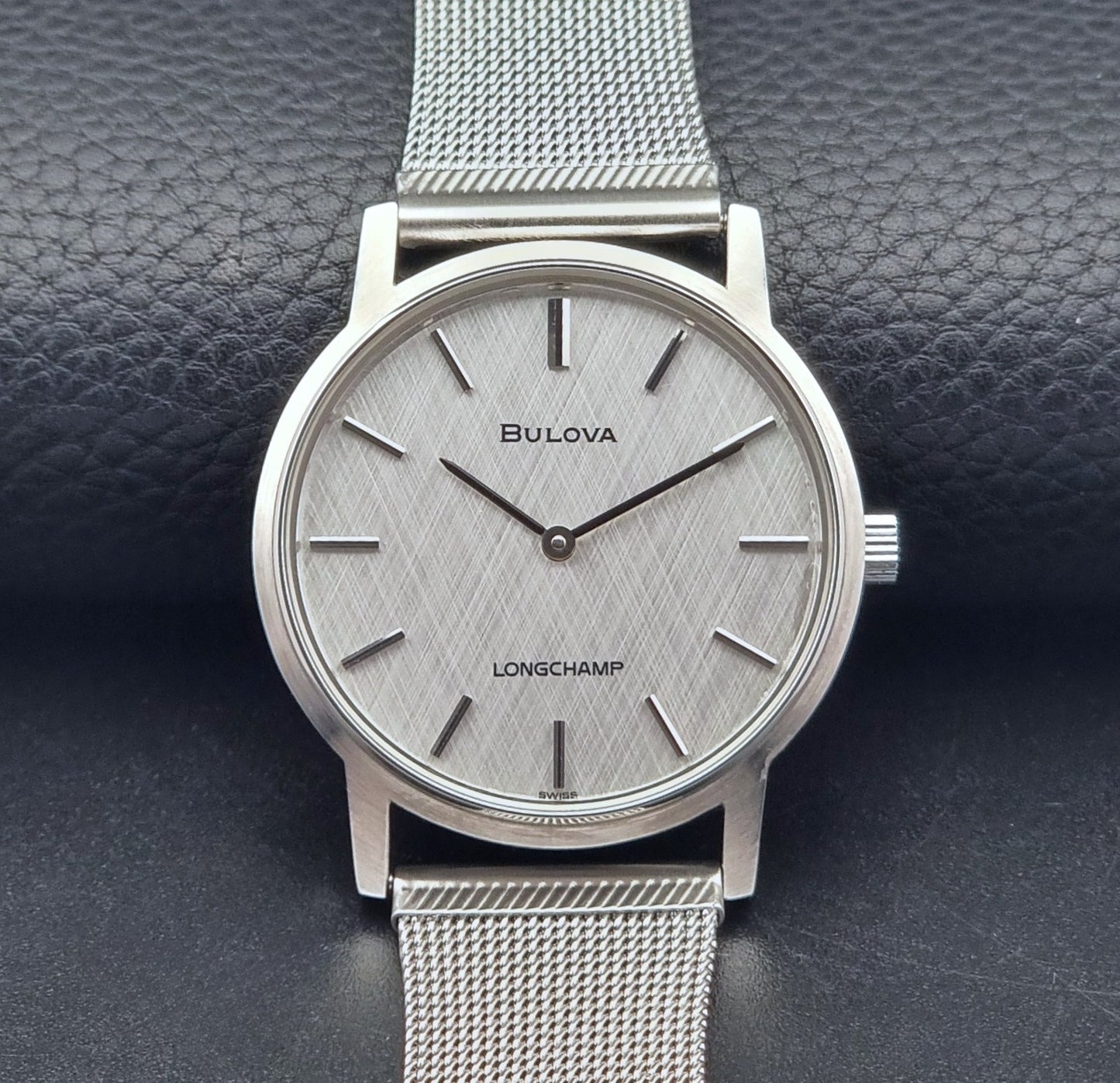 Vintage Bulova 9881 wristwatch Longchamps co-signed dial with a mesh band on a dark gray background front view