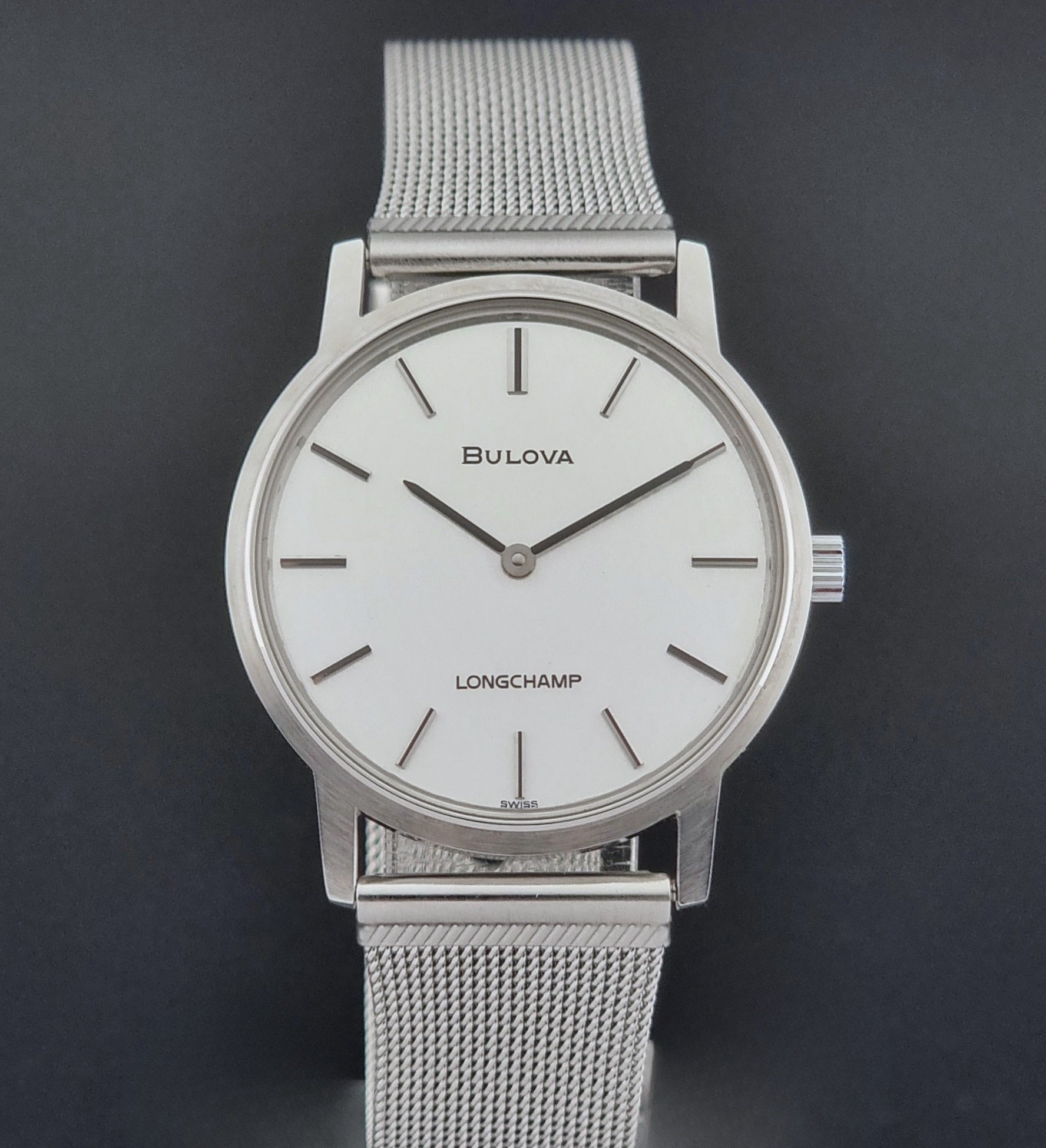 Vintage Bulova 9881 wristwatch Longchamps co-signed dial with a mesh band on a dark gray background close dial view