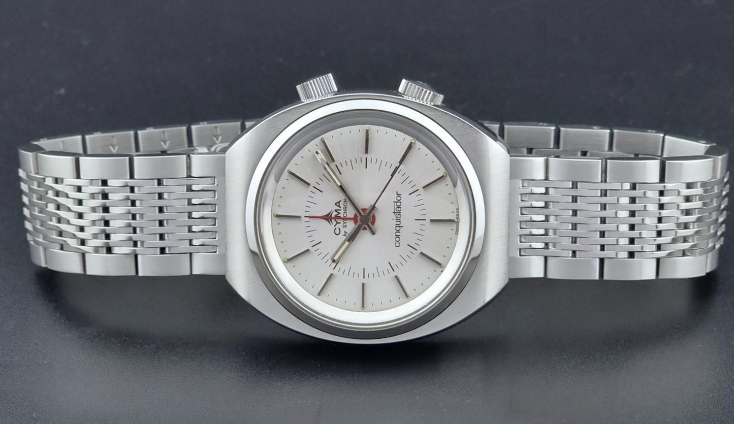 Vintage Cyma Alarm watch by Synchron a Conquistador 34270 with a detailed face on a dark surface dial view