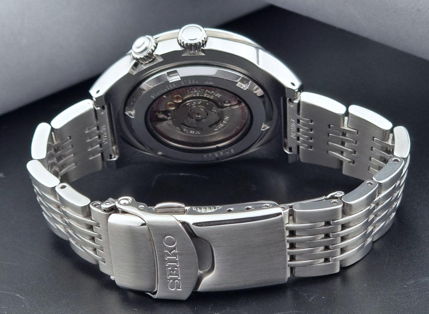 Seiko watch Mechasus SCFF009 GMT 4S12-0010 with a blue face on a dark gray background case back view