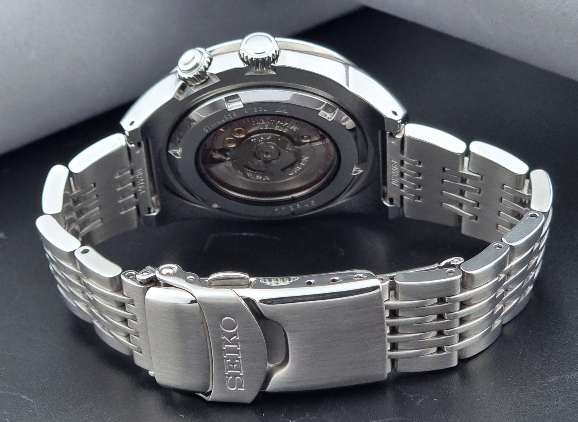 Seiko watch Mechasus SCFF009 GMT 4S12-0010 with a blue face on a dark gray background case back view