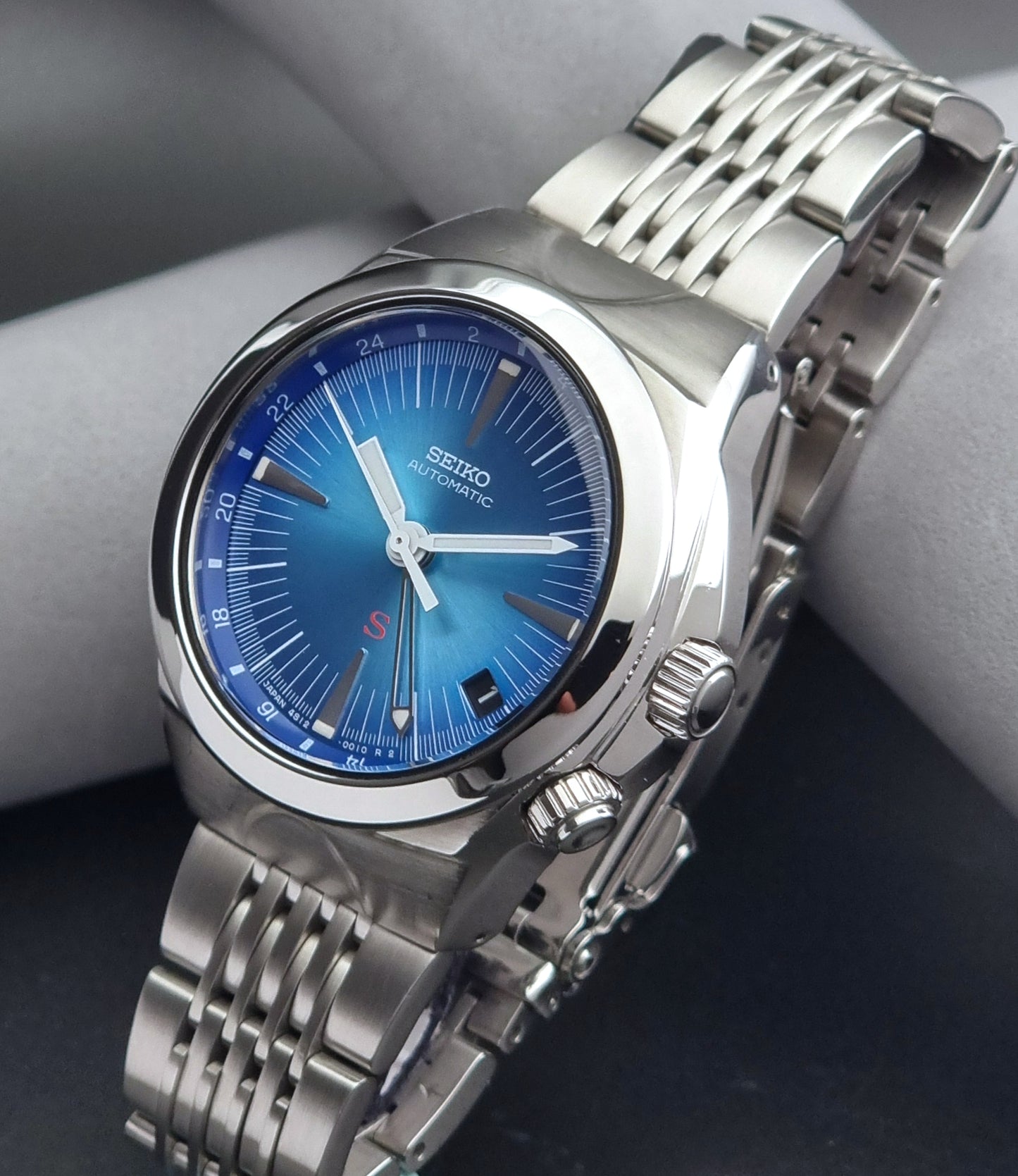 Seiko watch Mechasus SCFF009 GMT 4S12-0010 with a blue face on a dark gray background crown view