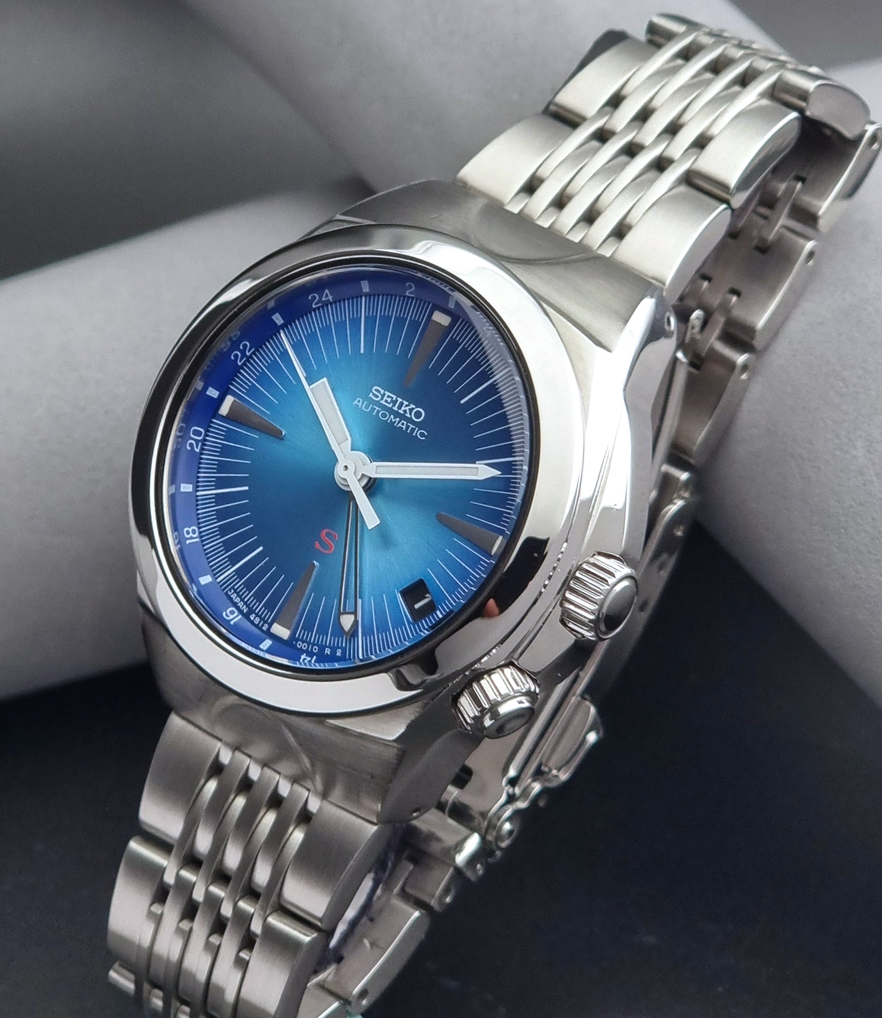 Seiko watch Mechasus SCFF009 GMT 4S12-0010 with a blue face on a dark gray background crown view