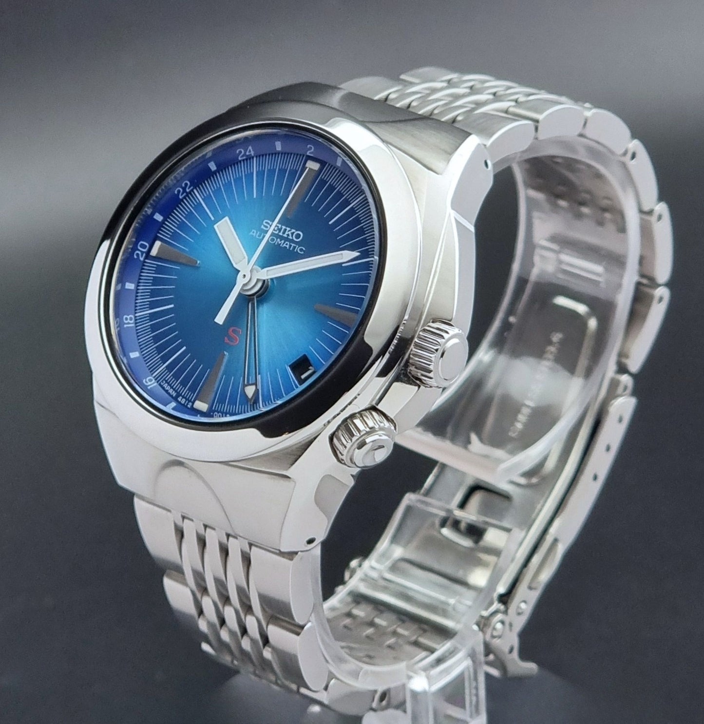 Seiko watch Mechasus SCFF009 GMT 4S12-0010 with a blue face on a dark gray background crown profile view