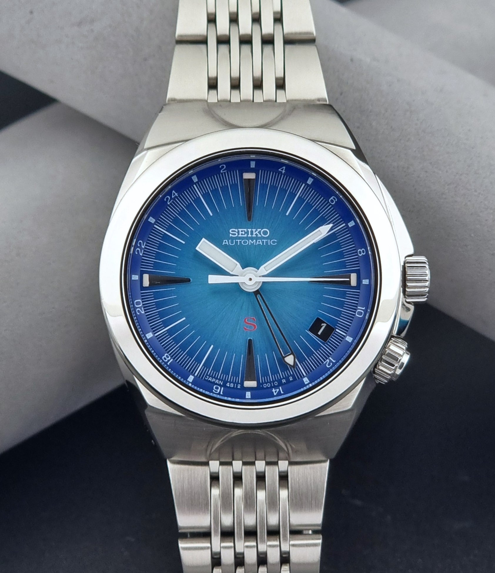 Seiko watch Mechasus SCFF009 GMT 4S12-0010 with a blue face on a dark gray background front view