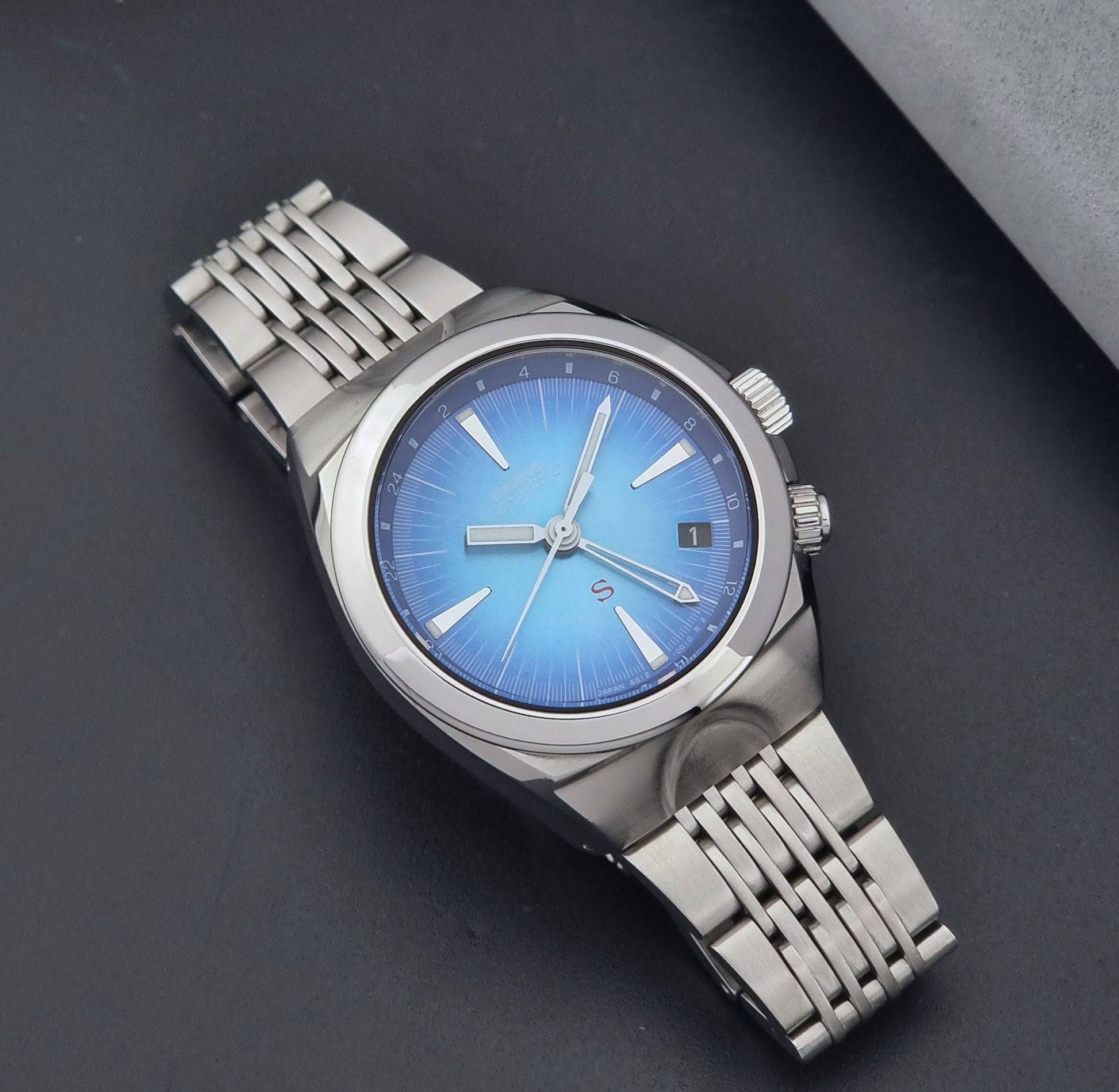 Seiko watch Mechasus SCFF009 GMT 4S12-0010 with a blue face on a dark gray background close up dial view