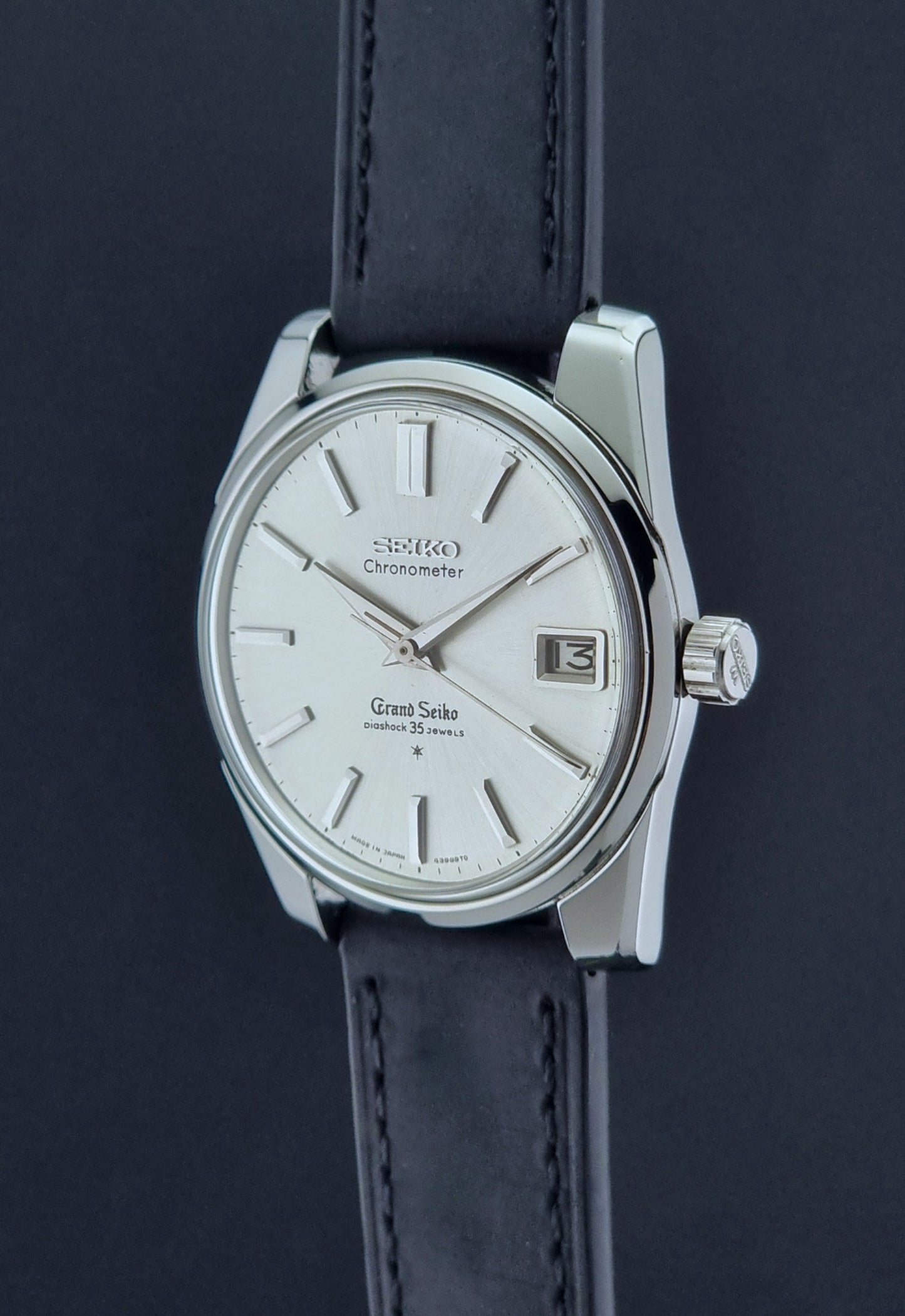 Vintage Grand Seiko Wristwatch with black leather strap on a dark background crown profile