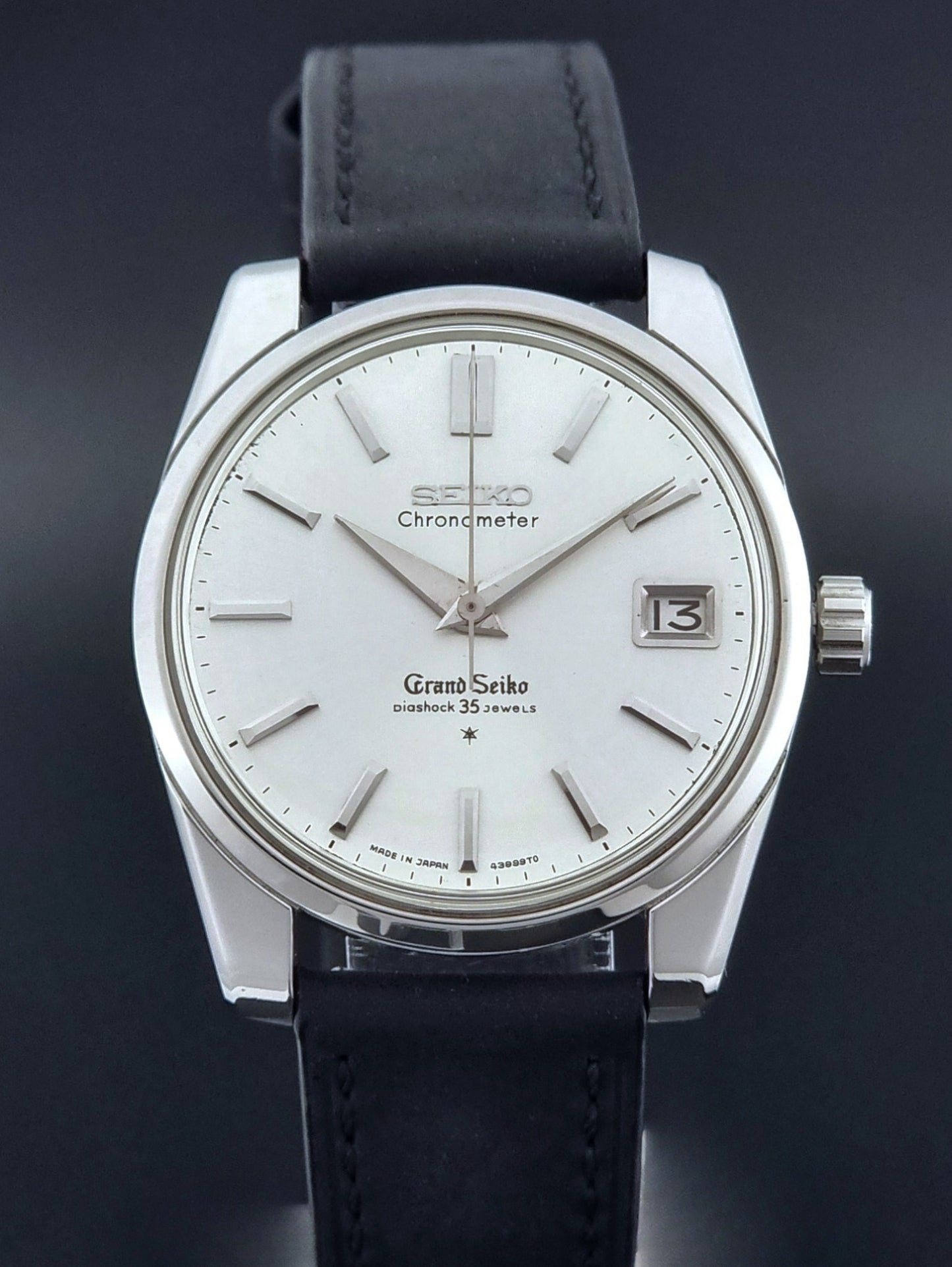Vintage Grand Seiko Wristwatch with black leather strap on a dark background dial view