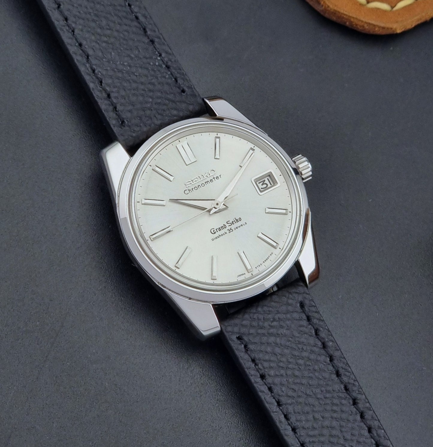 Vintage Grand Seiko Wristwatch 43999 leather strap on a gray background front view