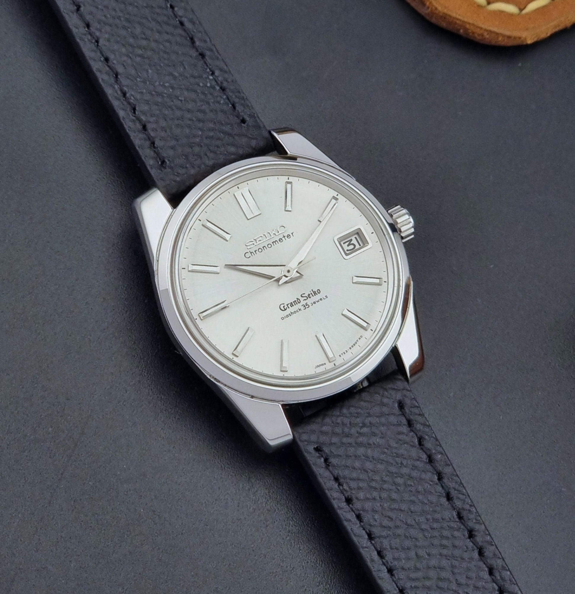 Vintage Grand Seiko Wristwatch 43999 leather strap on a gray background front view